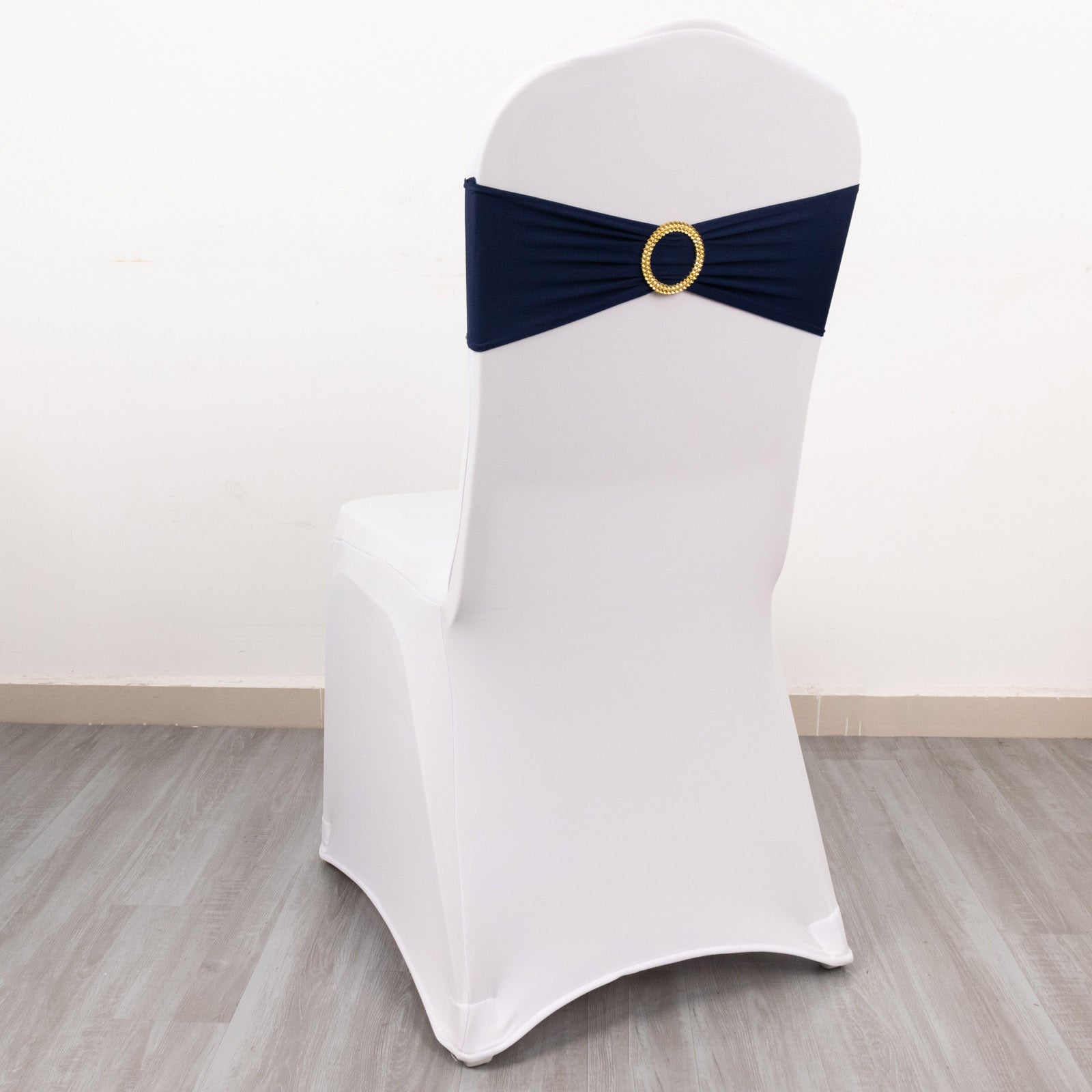 Navy blue spandex chair sash with gold diamond buckle on a white chair.
