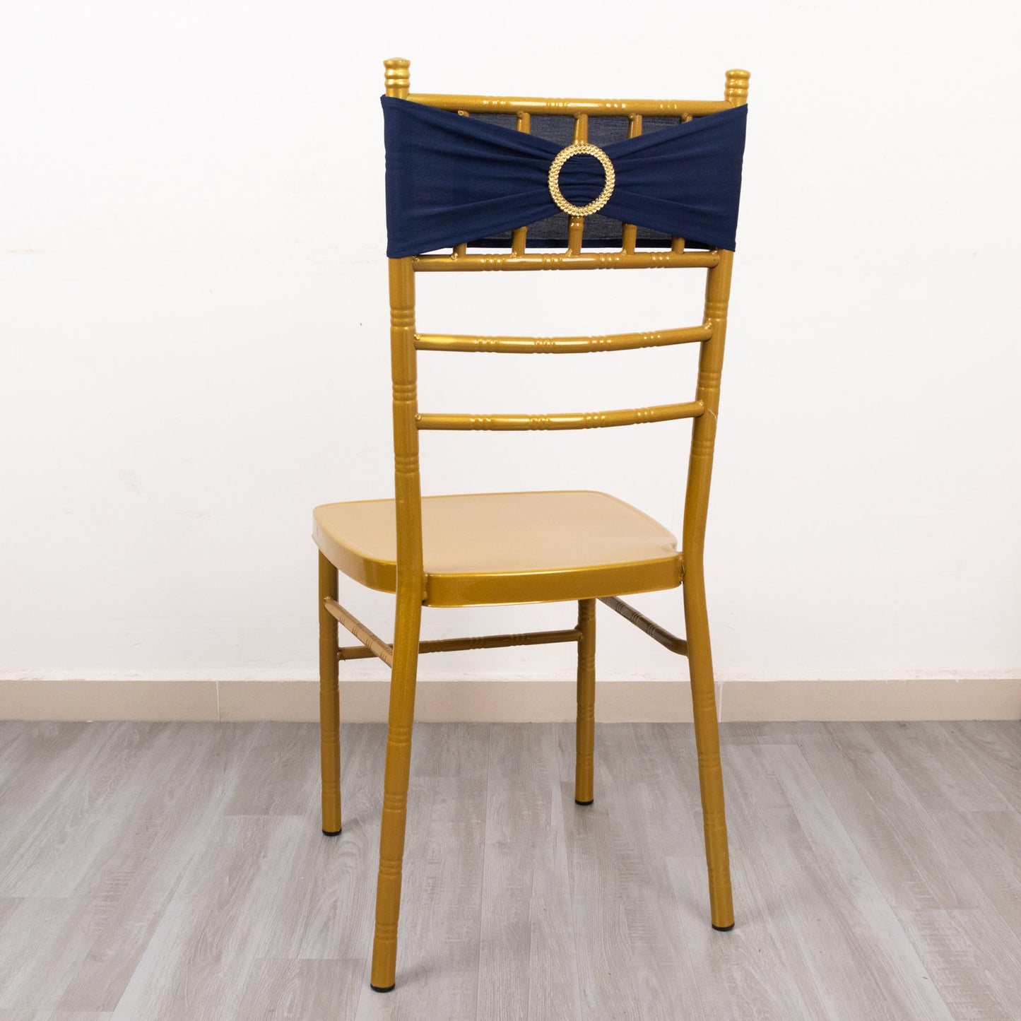 Navy blue spandex chair sash with gold diamond buckle on a gold chair.