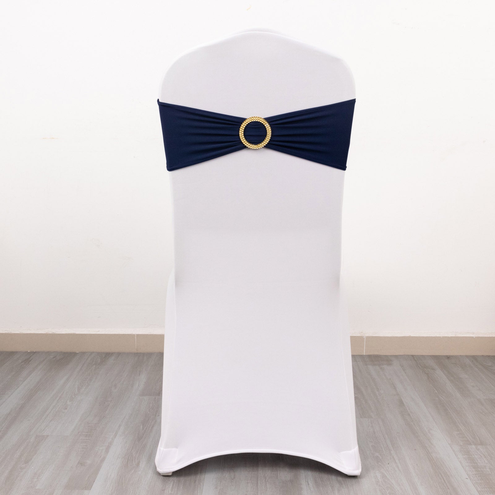 Navy blue spandex chair sash with gold diamond buckle on white chair.