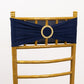 Navy blue spandex chair sash with gold diamond buckle on a golden chair.