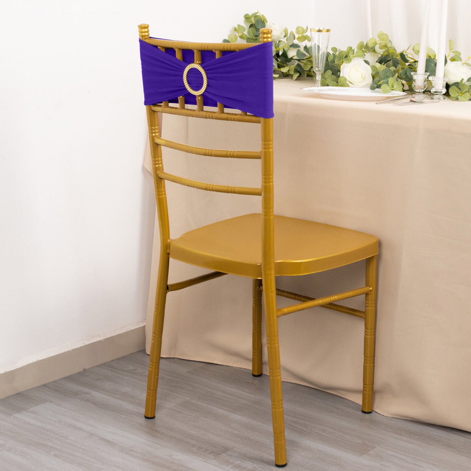 Purple spandex chair sash with gold diamond buckle on a gold chair.