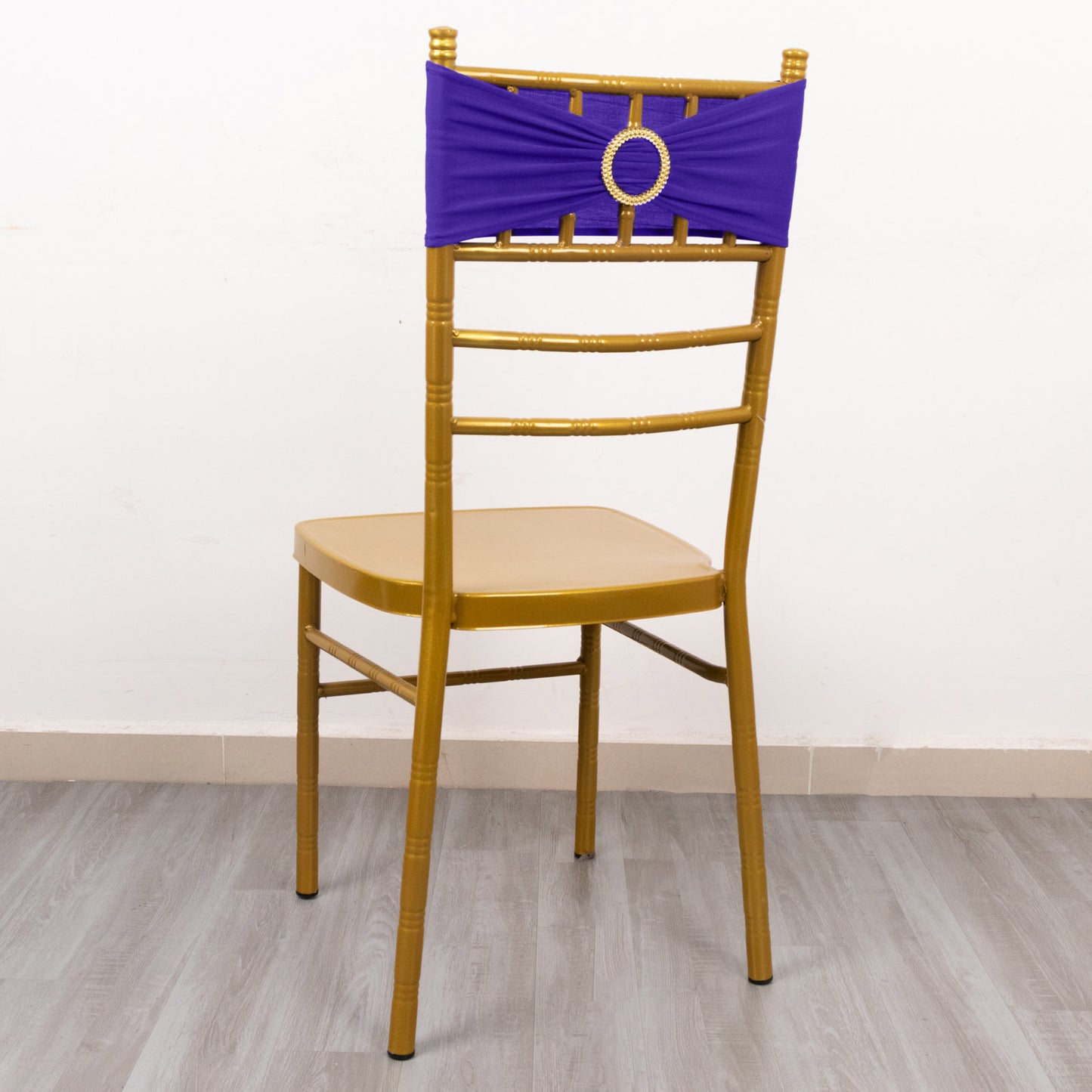 Purple spandex chair sash with gold diamond buckle on a chair.
