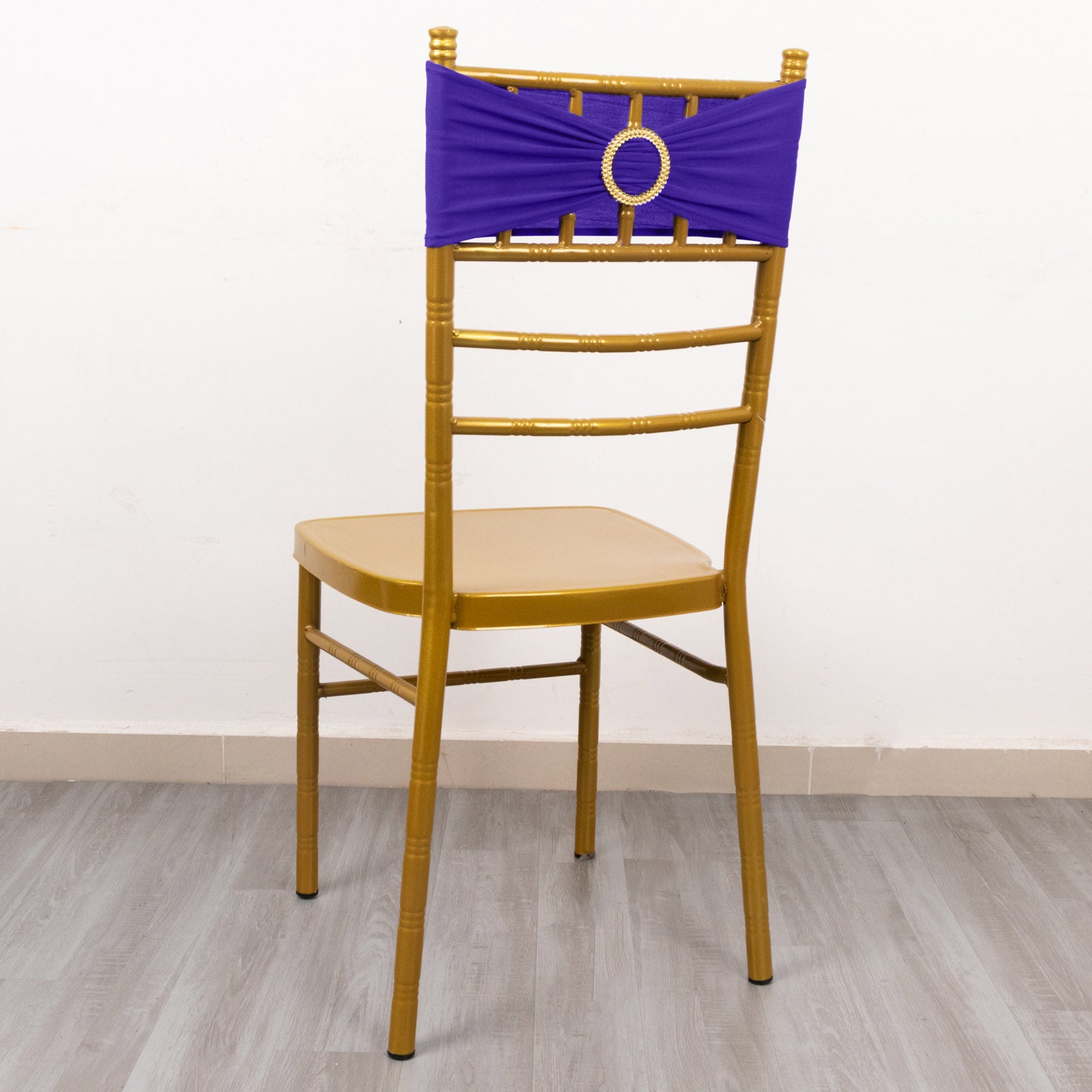 Purple spandex chair sash with gold diamond buckle on a chair.
