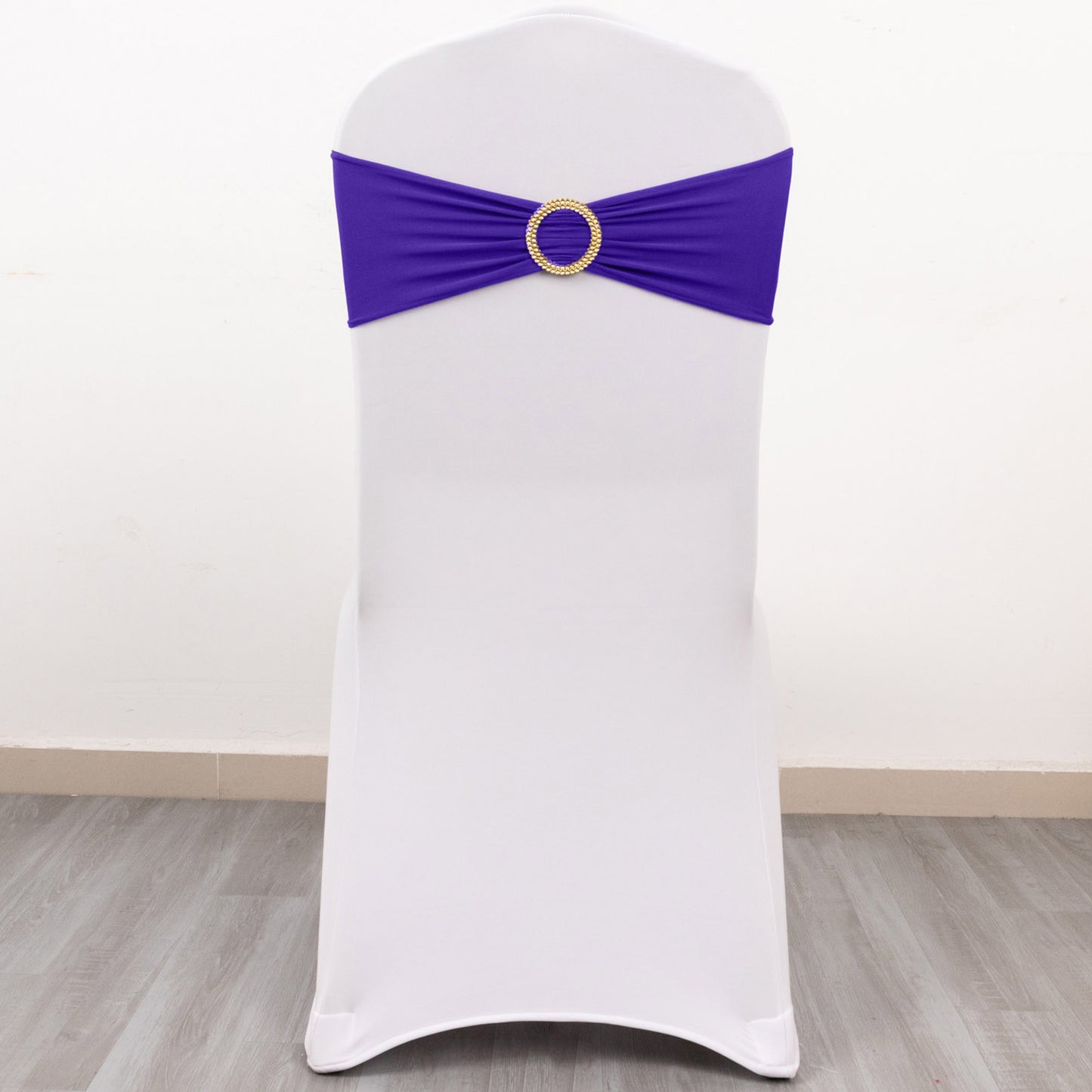 Purple spandex chair sash with gold diamond buckle on a white chair.