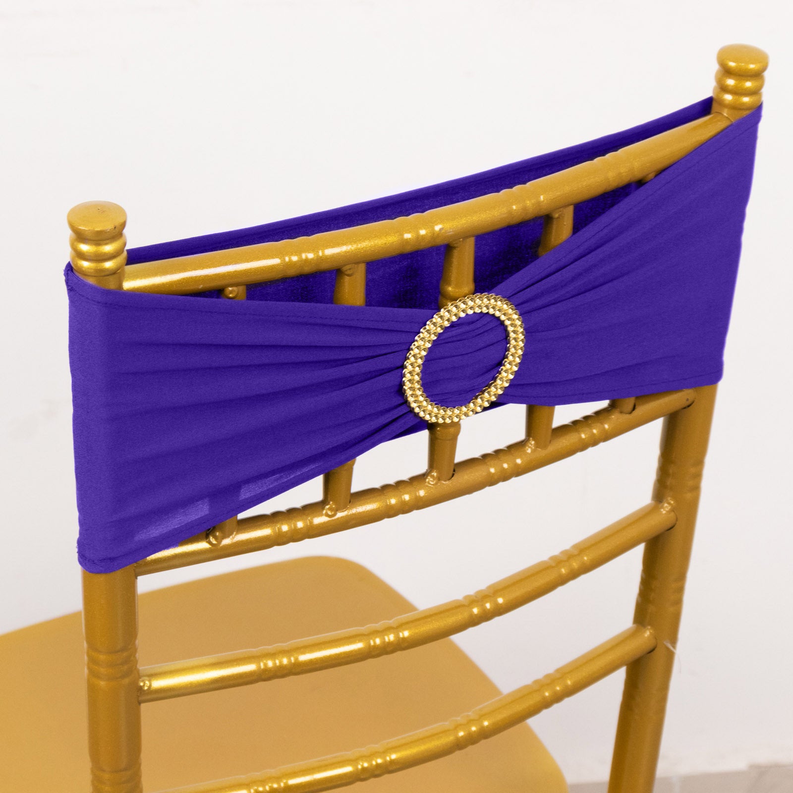 Purple spandex chair sash with gold diamond buckle on a chair.