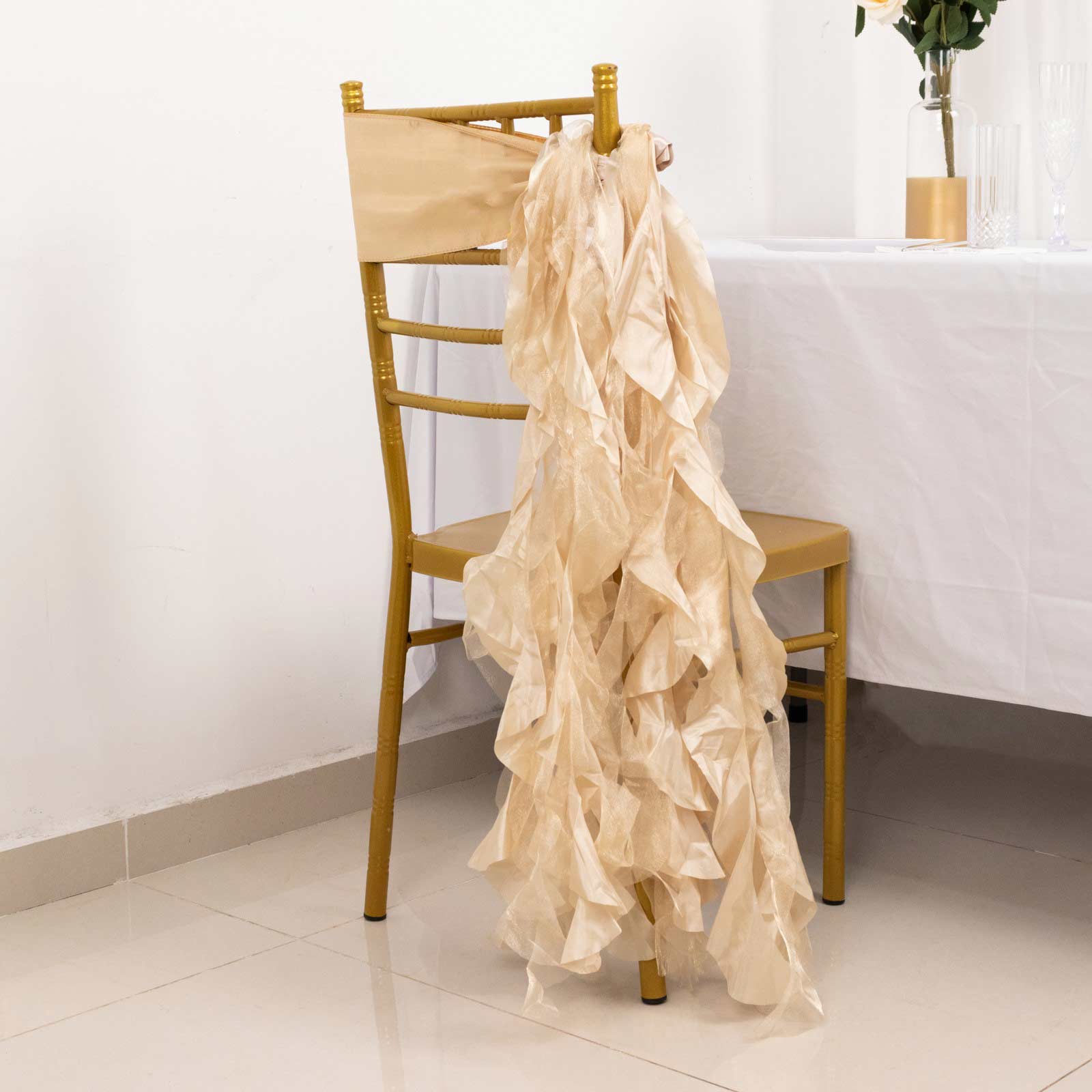 Beige curly willow chiffon satin chair sashes on a gold chair.