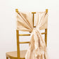 Beige chiffon satin chair sashes tied on a gold chair.