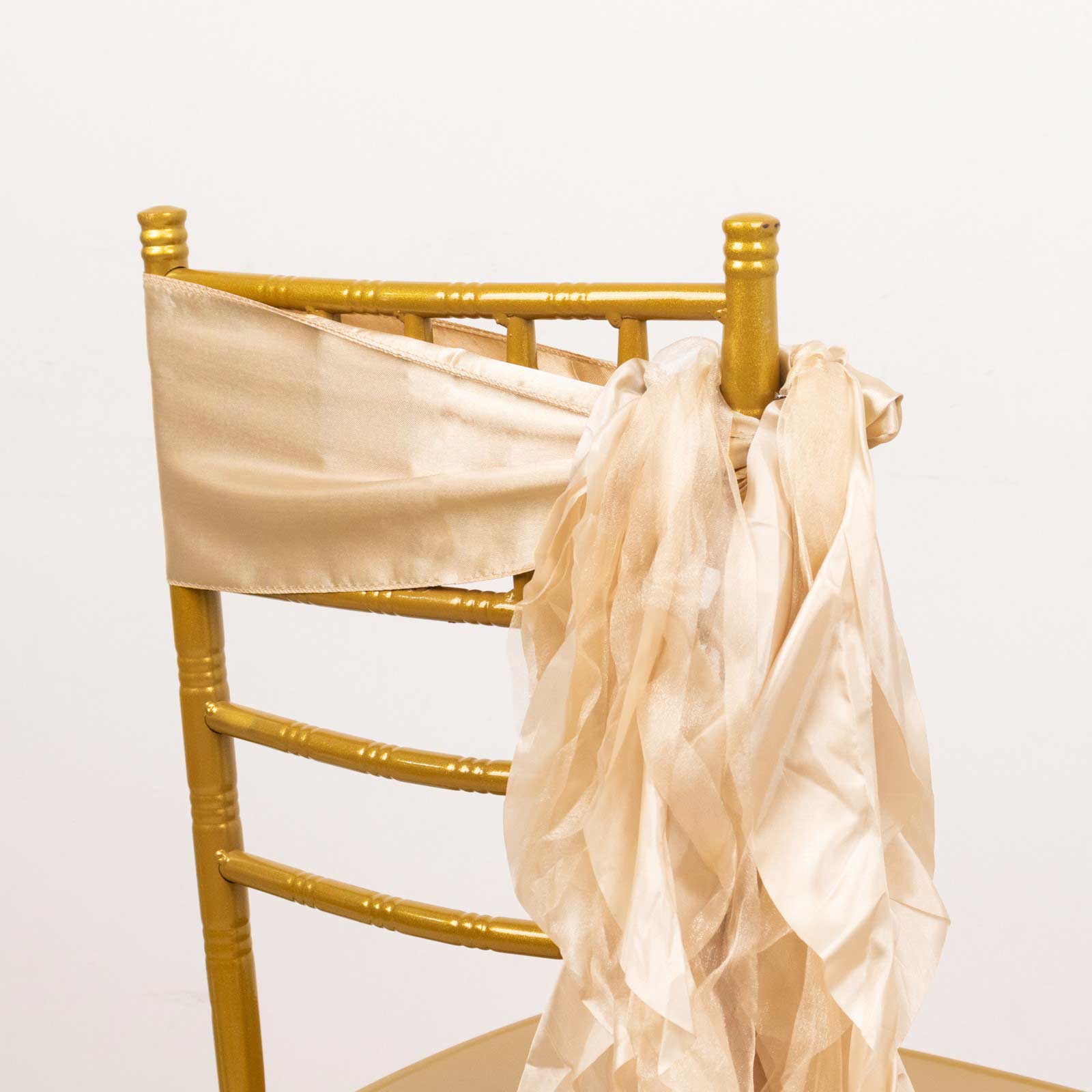 Beige curly willow chiffon satin chair sashes tied on a gold chair.