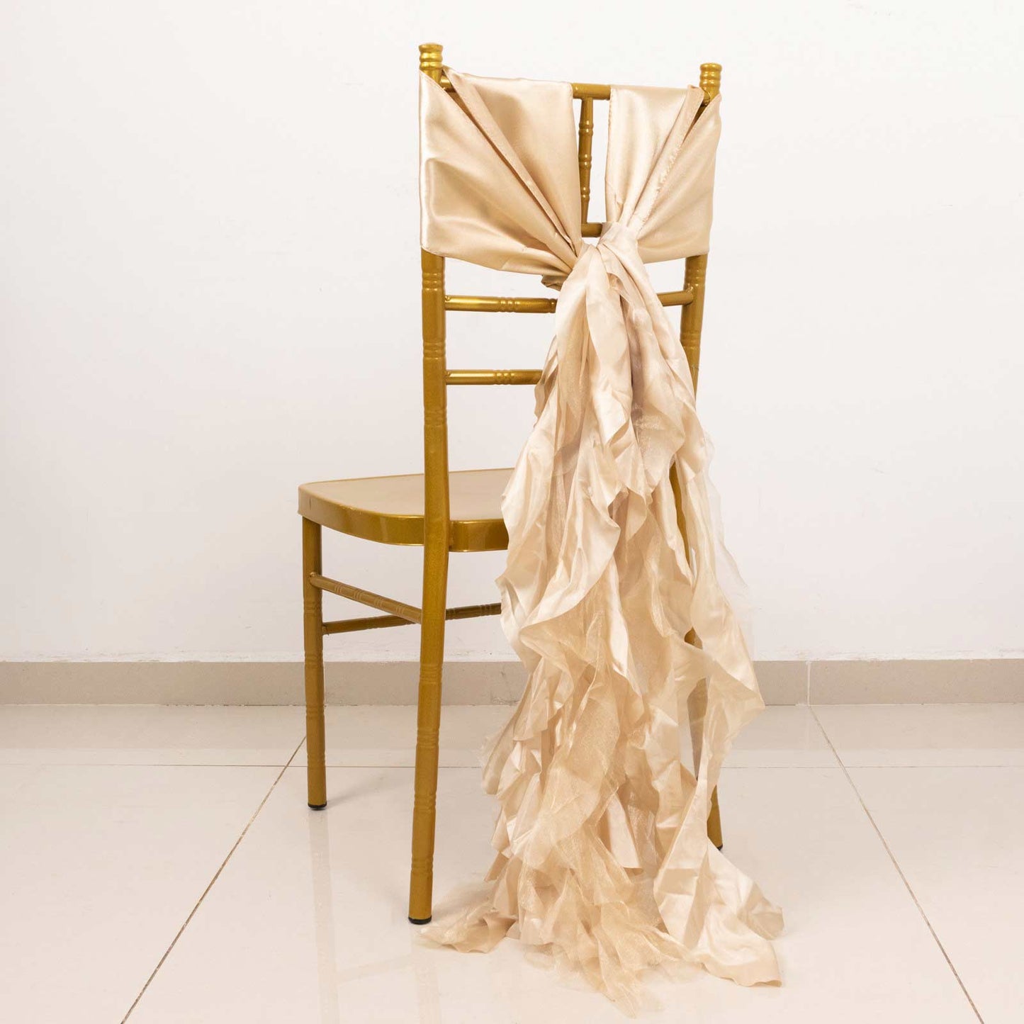 Beige curly willow chiffon satin chair sashes on a gold chair.