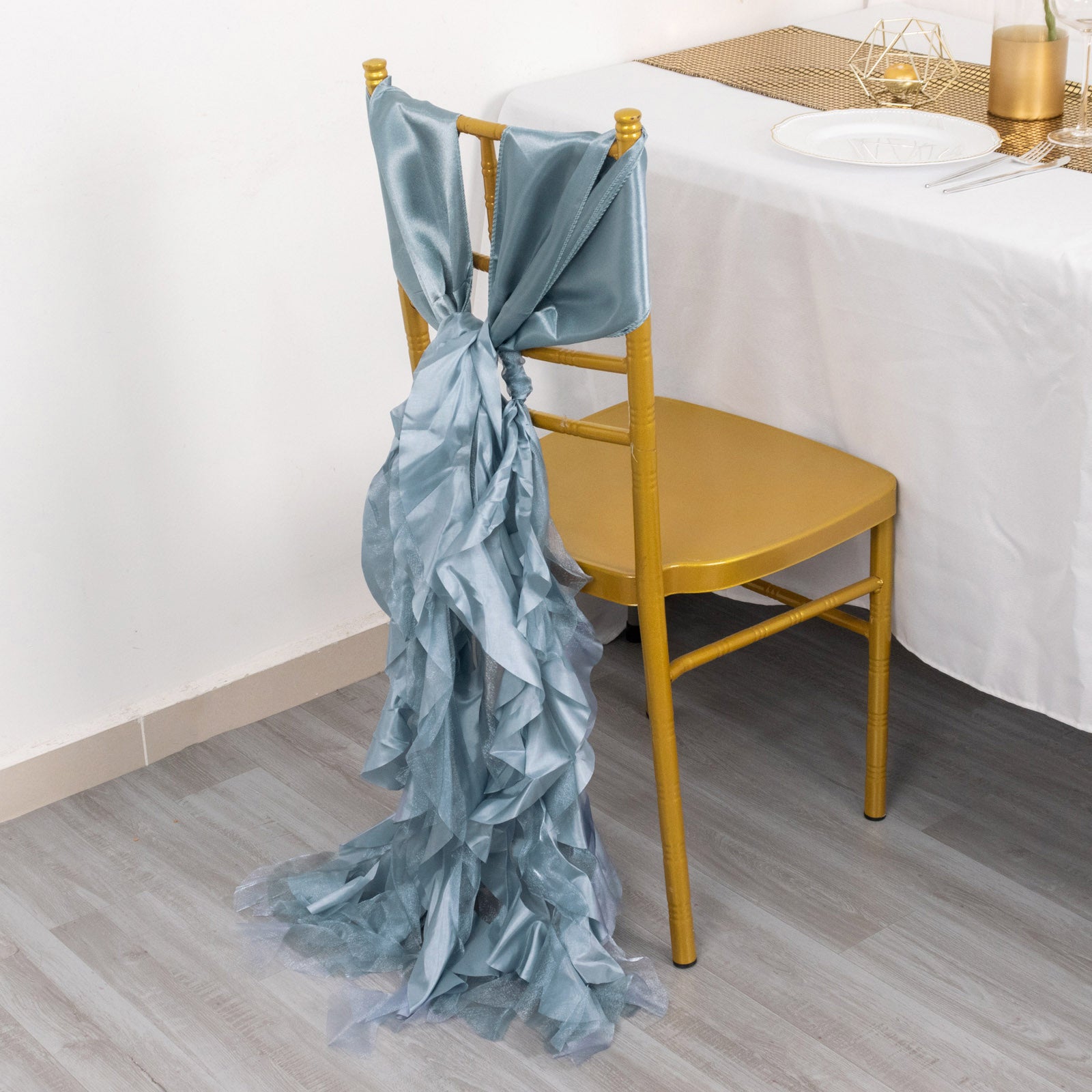 Dusty blue chiffon satin chair sashes on a gold chair.