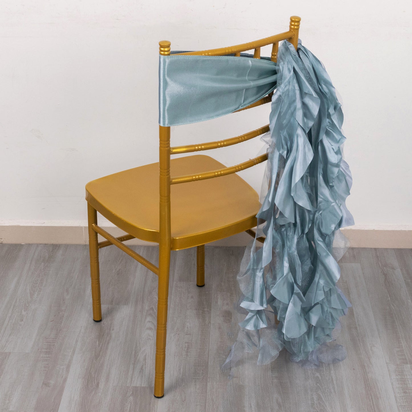 Dusty blue chiffon satin chair sash on a gold chair.