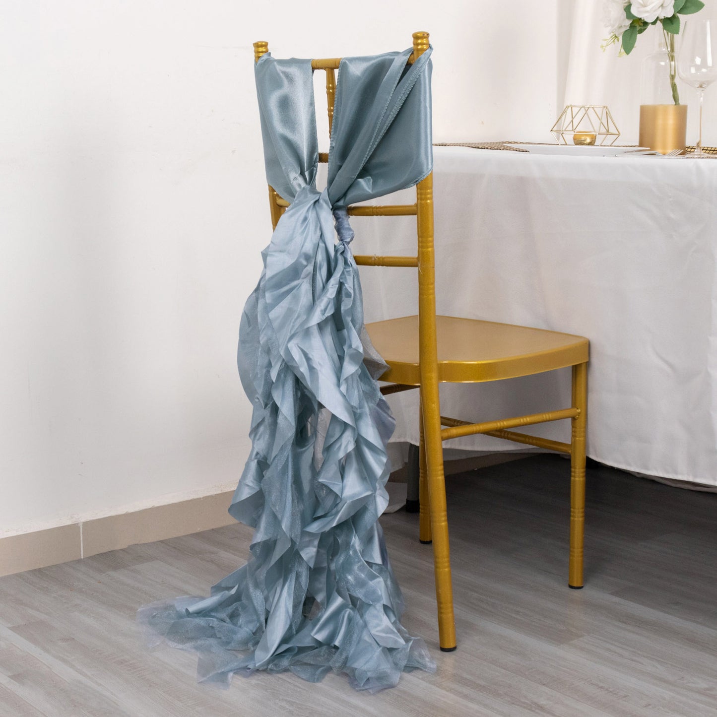 Dusty blue chiffon satin chair sash on a gold chair.