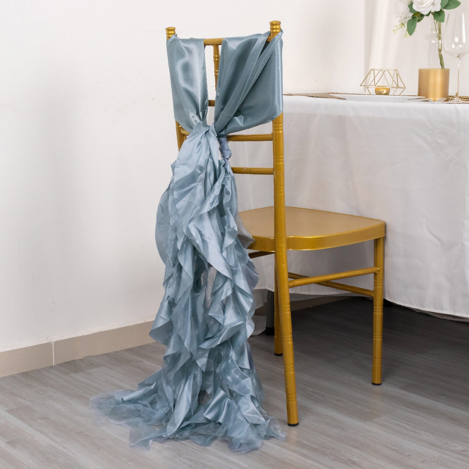 Dusty blue chiffon satin chair sash on a gold chair.