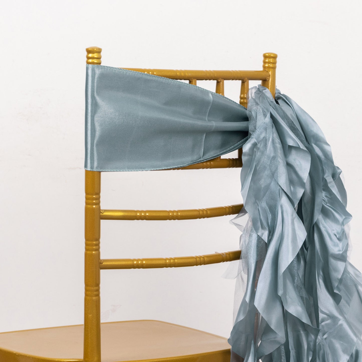 Dusty blue chiffon satin chair sash on a gold chair.