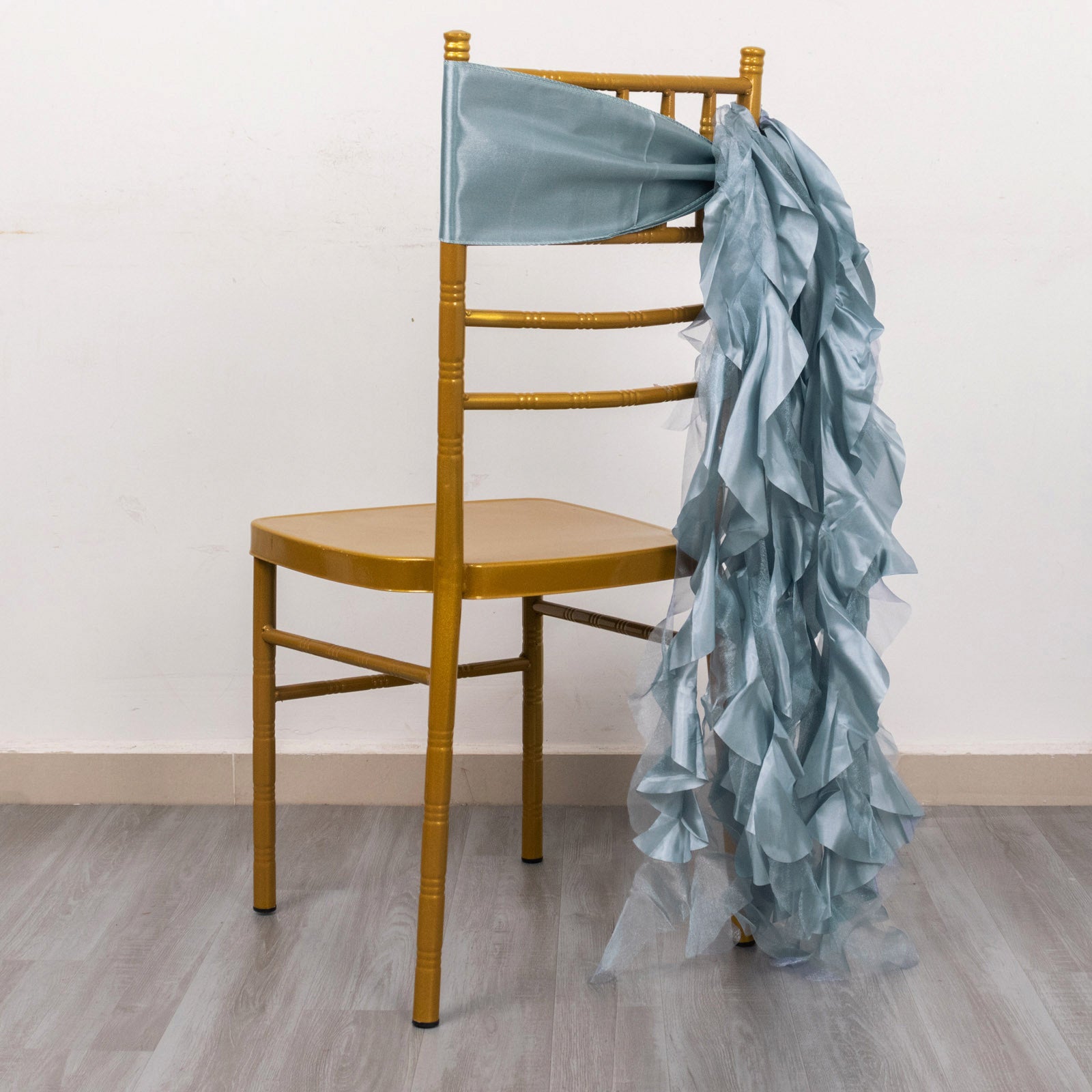 Dusty blue chiffon satin chair sash draped on a gold chair.