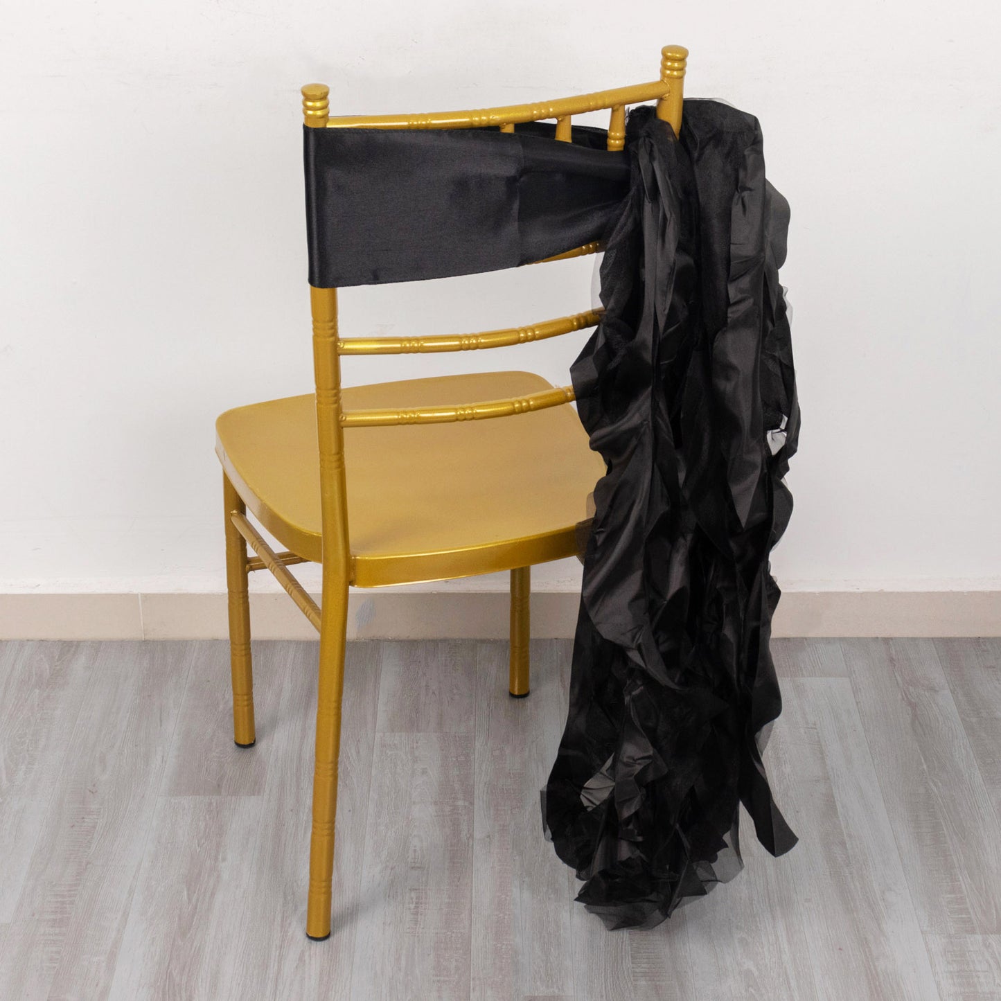 Black chiffon satin chair sash draped over a gold chair.