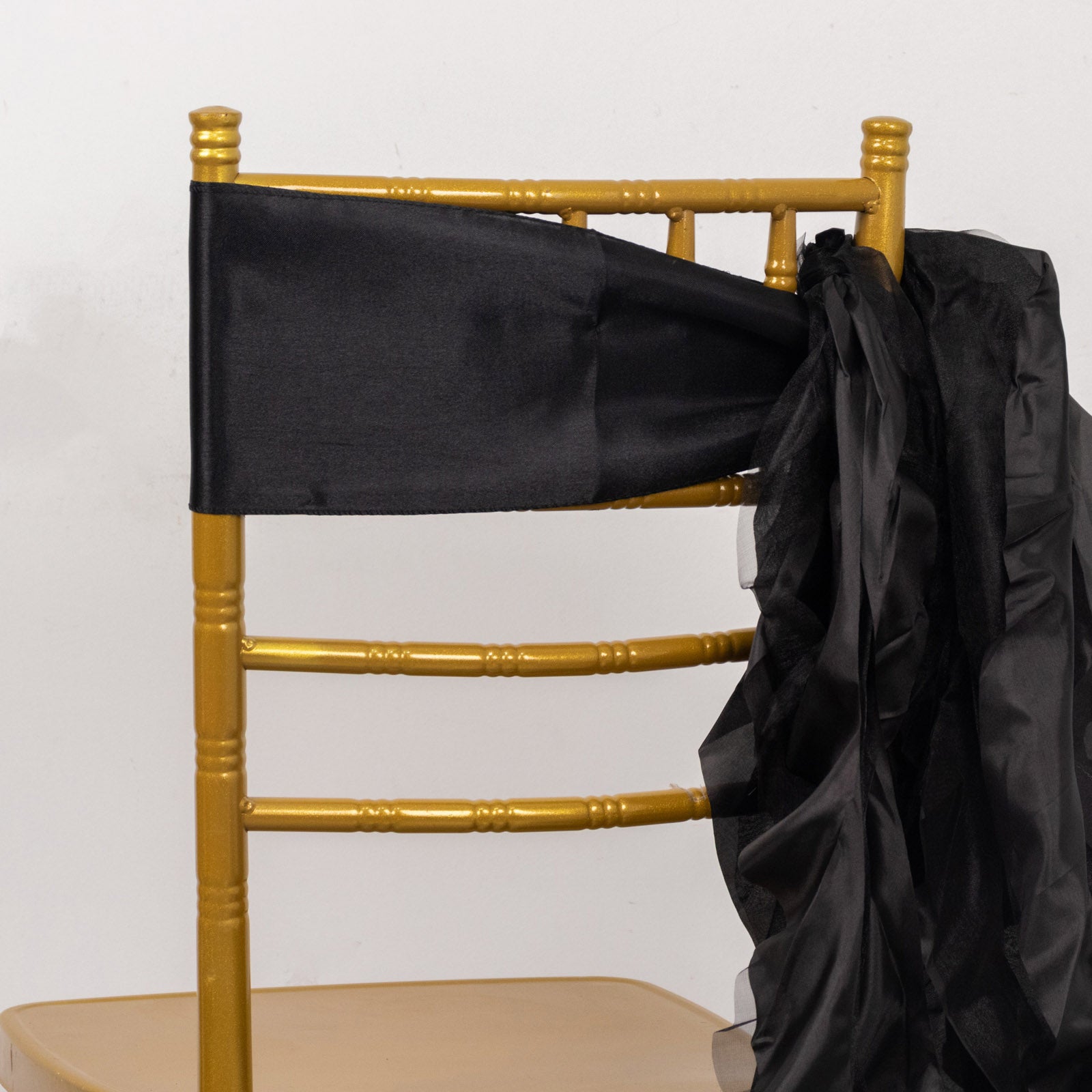 Black chiffon satin chair sash on a gold chiavari chair.