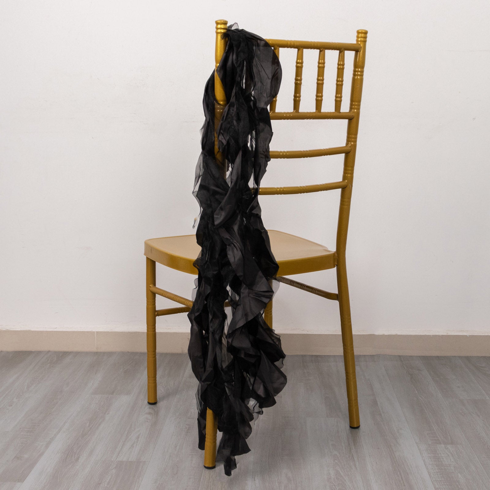 Black curly willow chiffon satin chair sash draped on a gold chair.