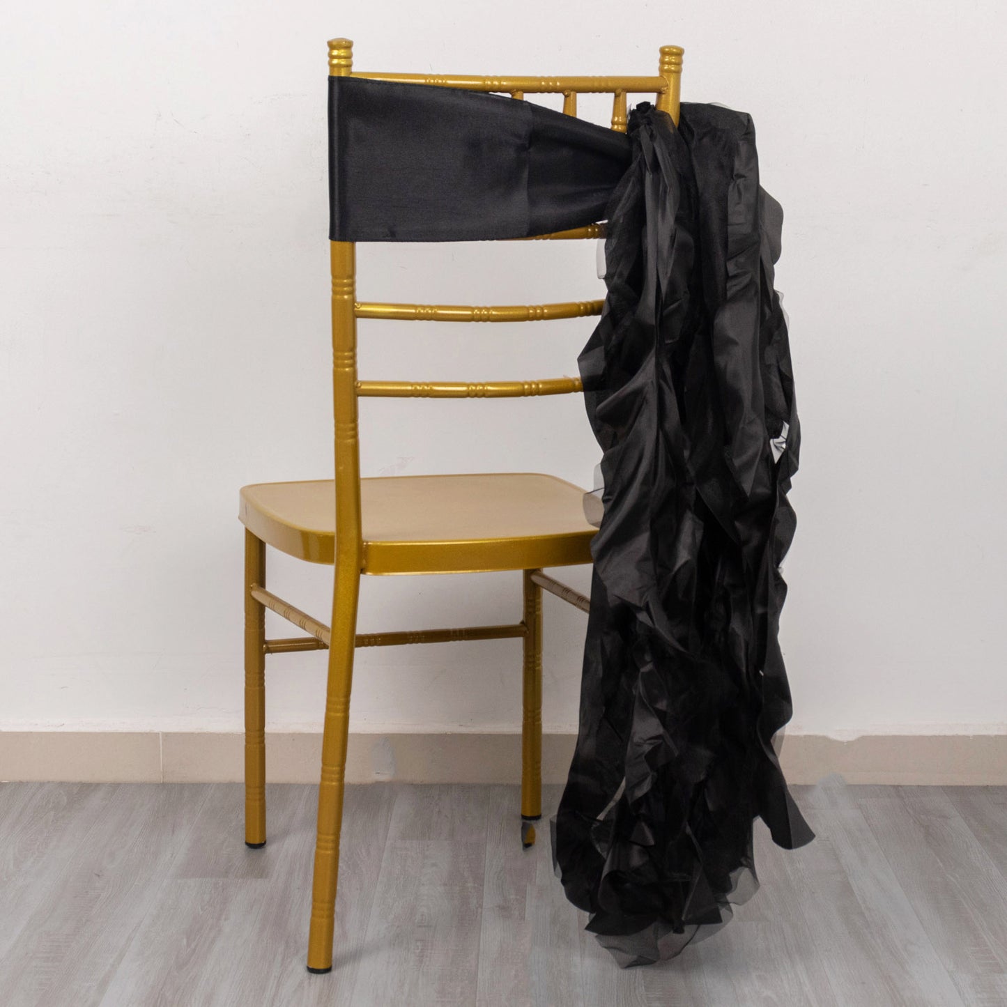 Black curly willow chiffon satin chair sash draped on a gold chair.