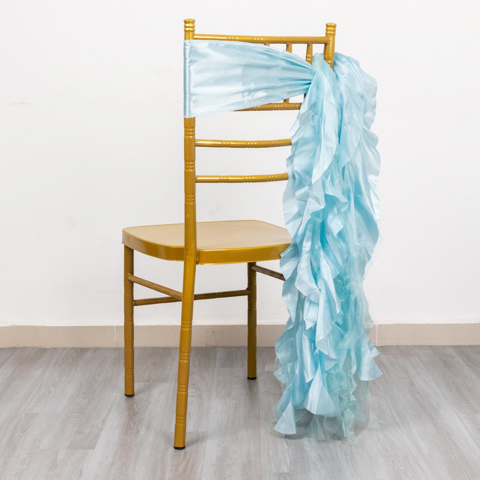 Light blue curly chiffon satin chair sash draped on a gold chair.
