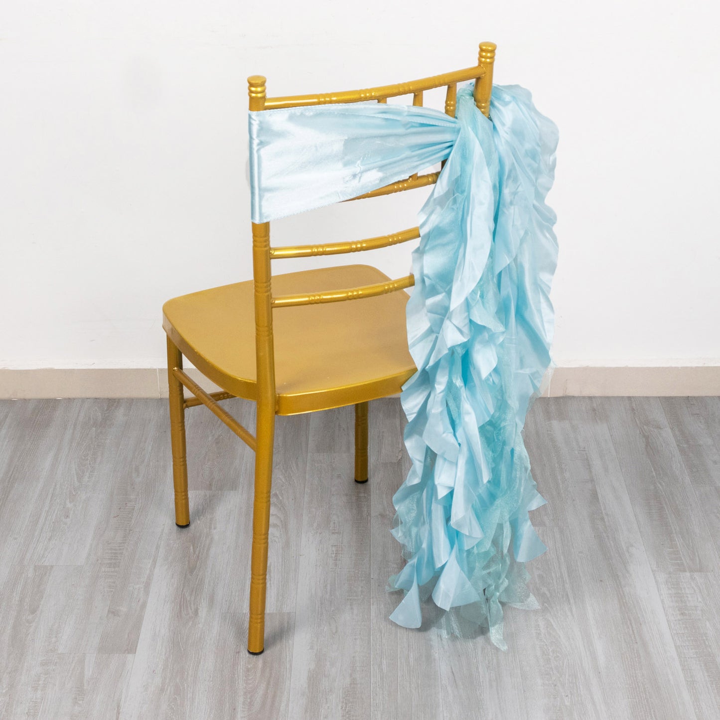 Light blue curly willow chiffon satin chair sash on a gold chair.