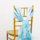 Light blue chiffon satin chair sash tied on a gold chair.