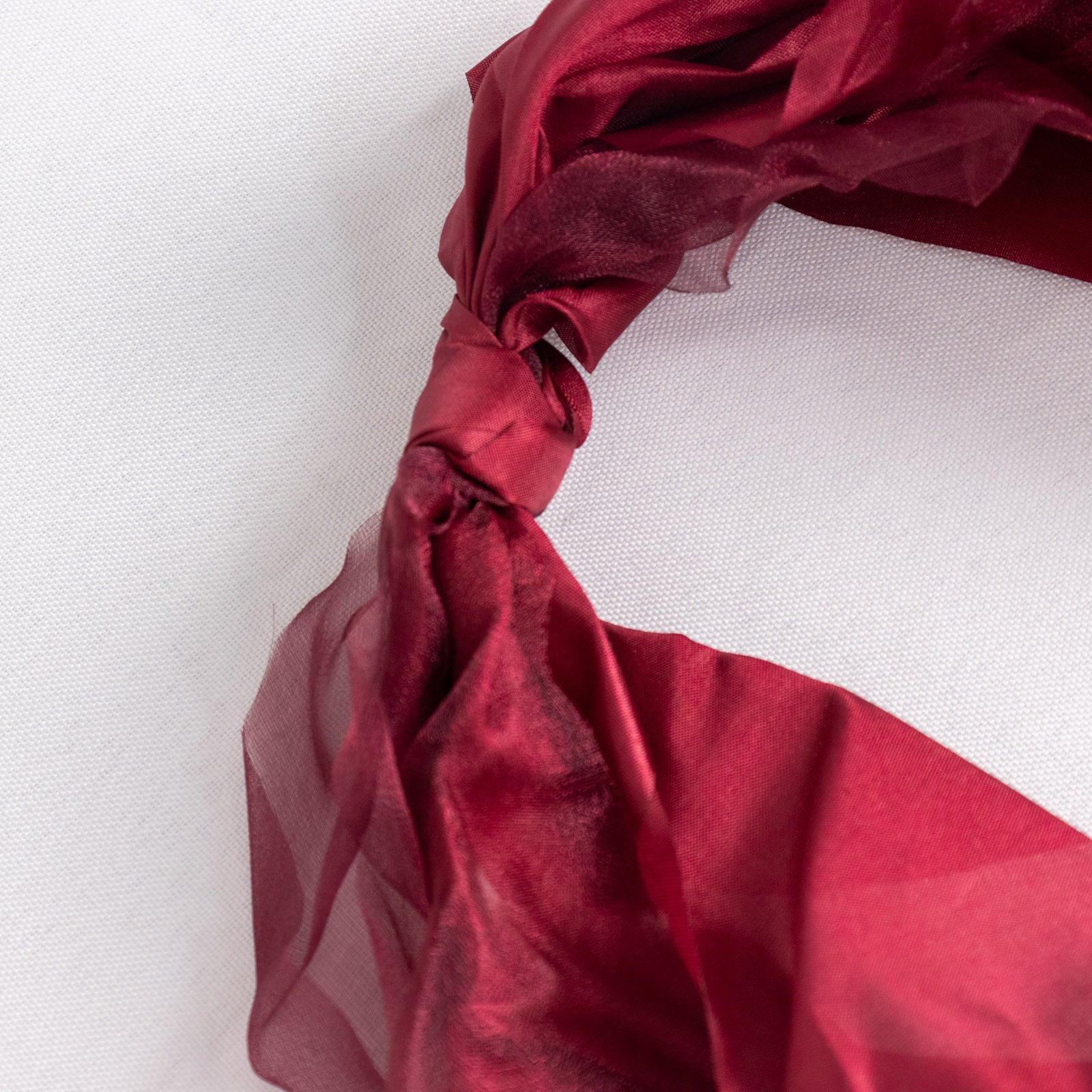 Burgundy chiffon satin chair sashes tied in a decorative knot.