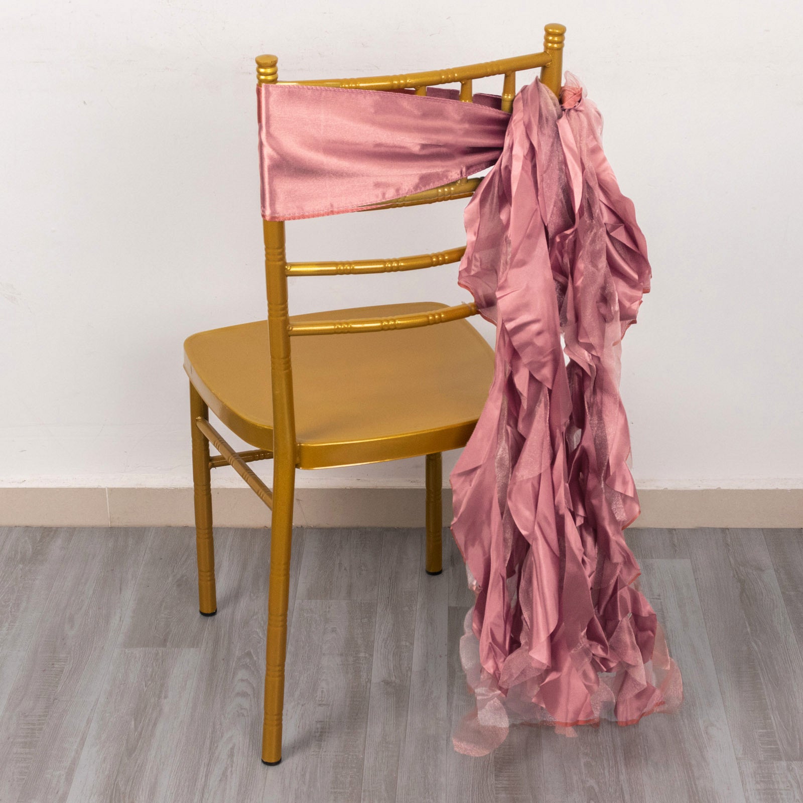 Cinnamon rose curly chiffon satin chair sash on a gold chair.