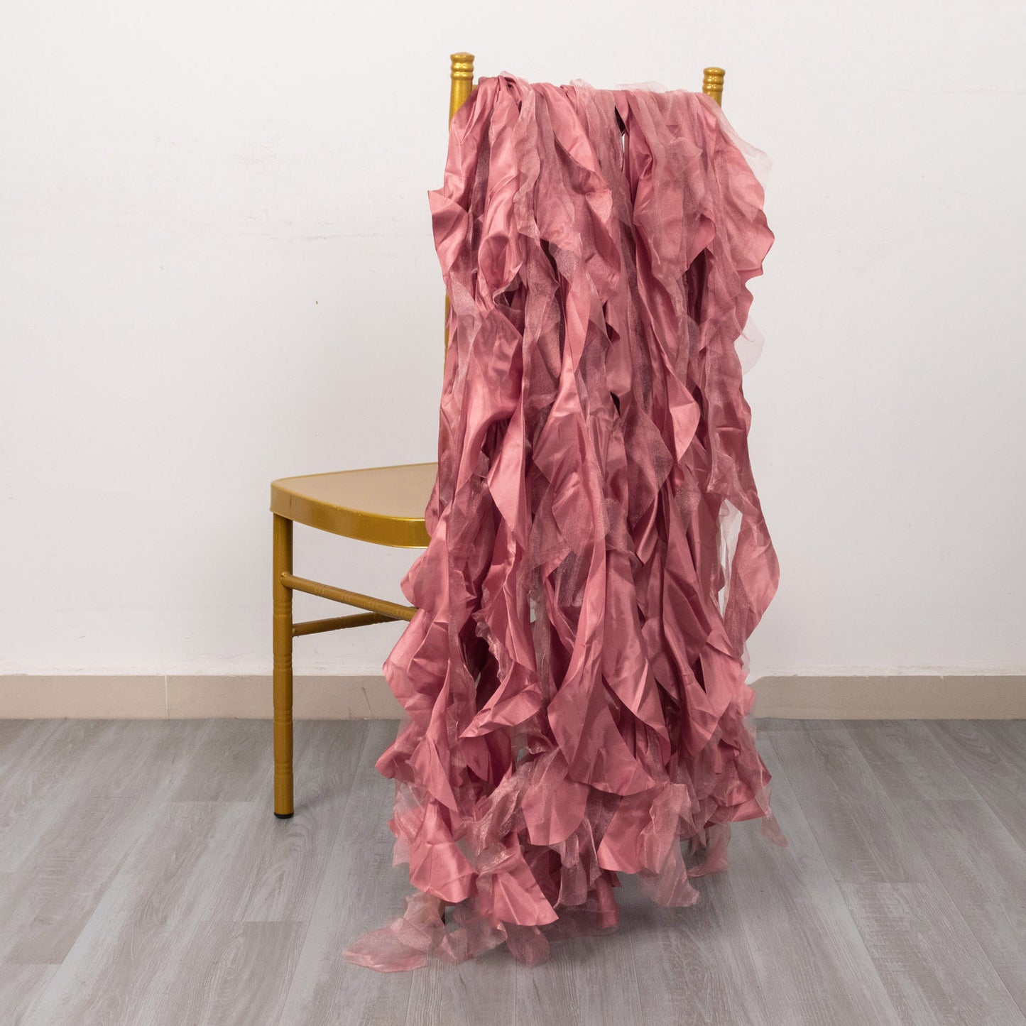 Cinnamon rose curly chiffon satin chair sashes draped over a chair.