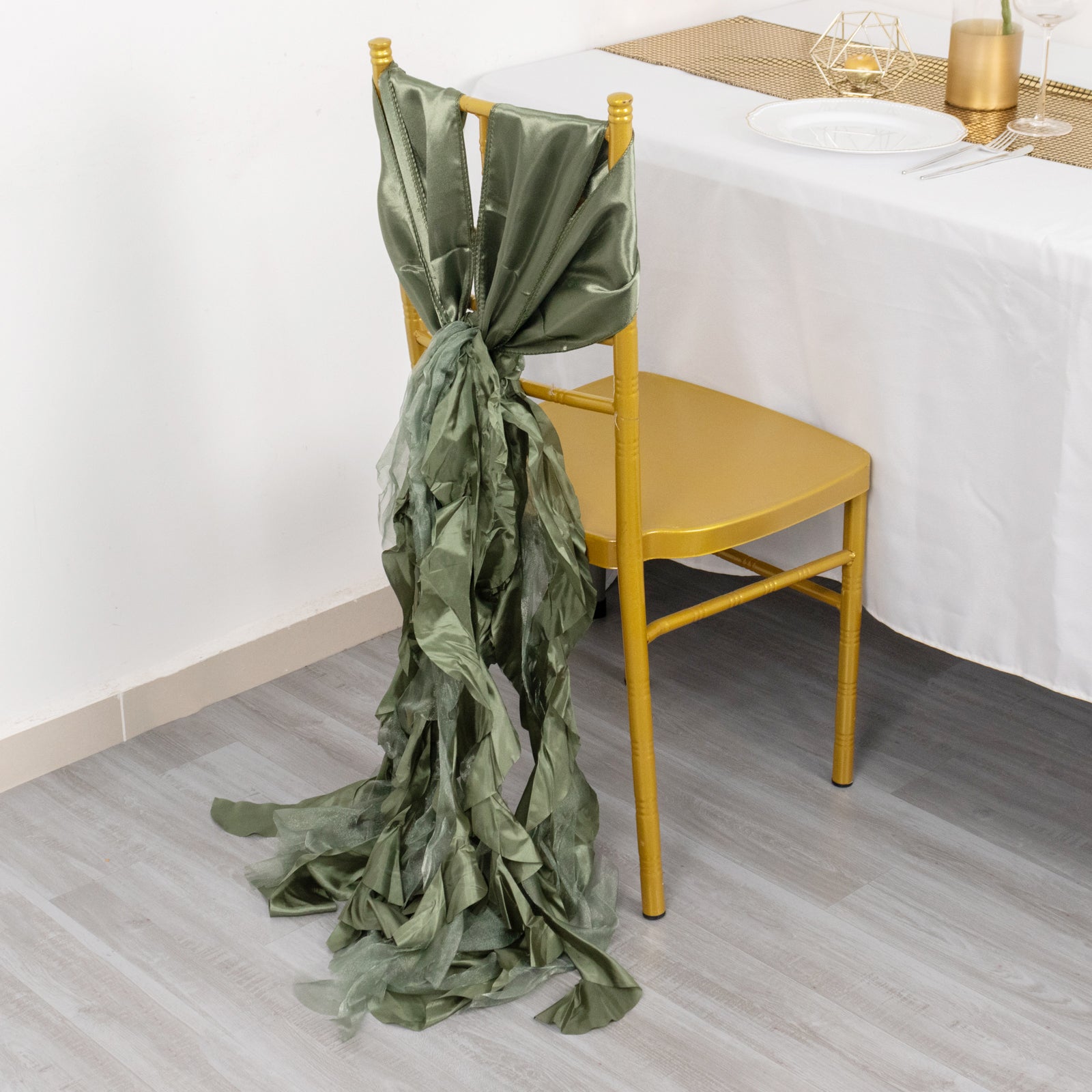 Dusty sage green chiffon satin chair sash on a gold chair.