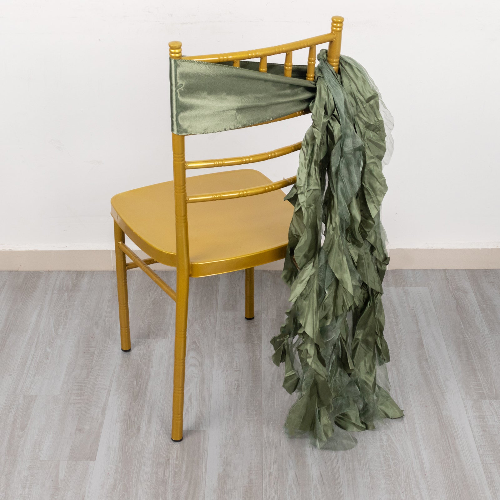 Dusty sage green chiffon satin chair sashes draped on a chair.