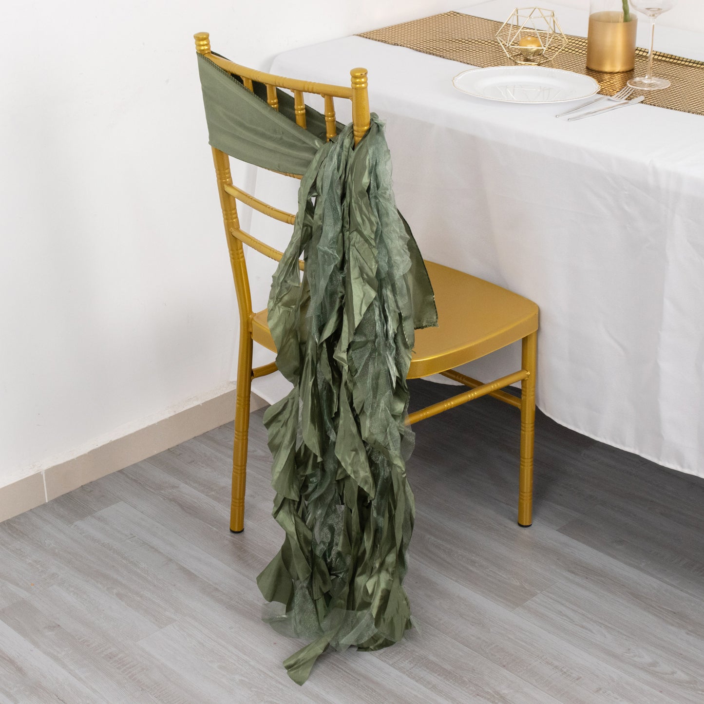 Dusty sage green curly willow chiffon satin chair sash on a gold chair.