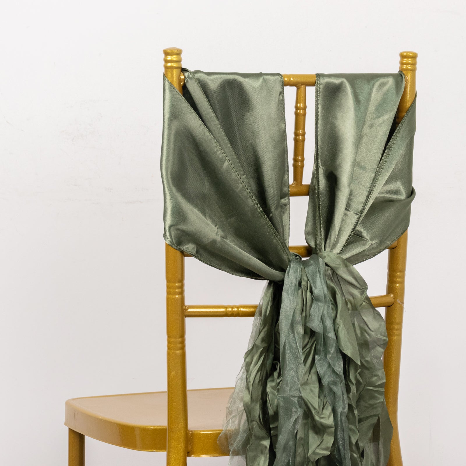 Dusty sage green curly chiffon satin chair sash tied on a gold chair.