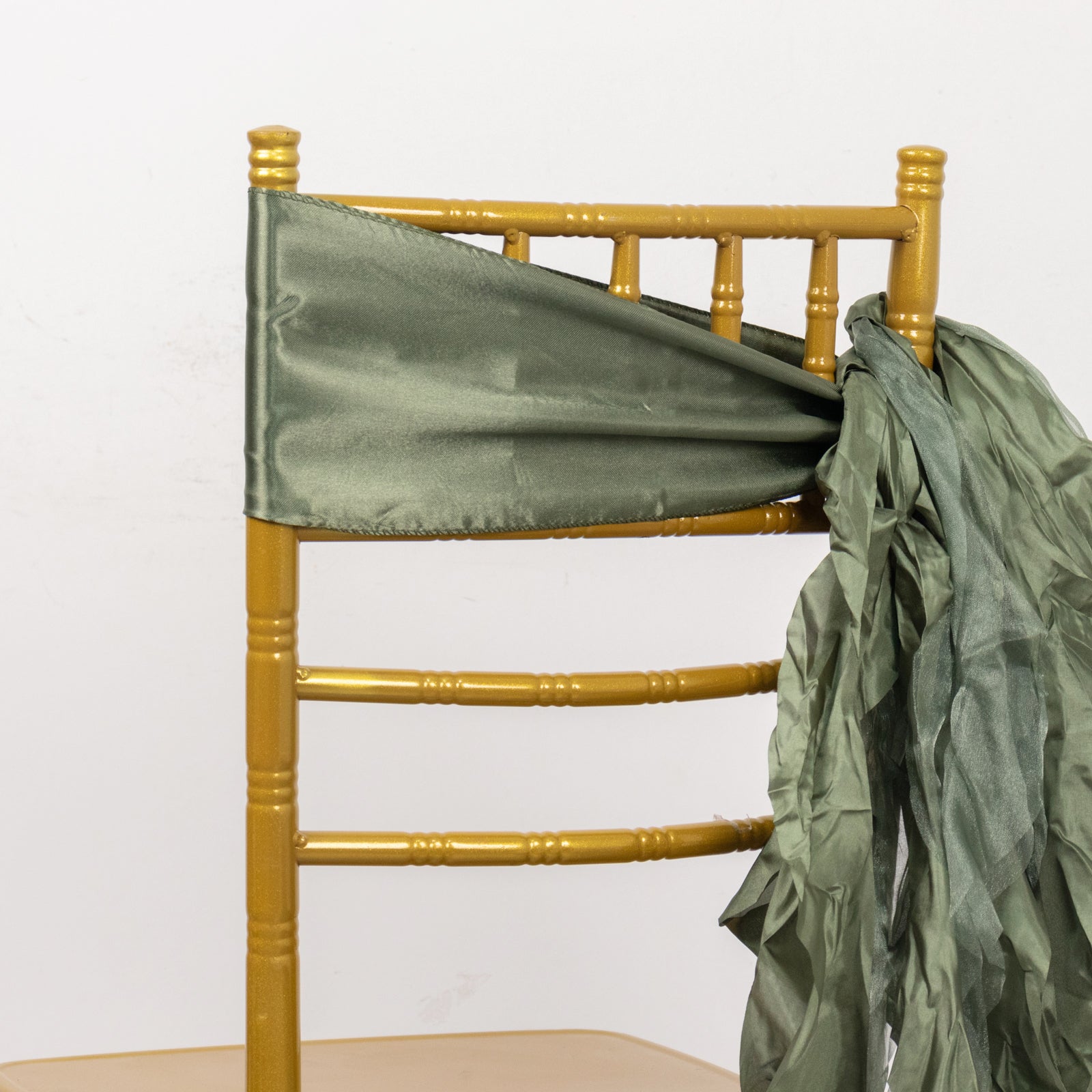 Dusty sage green chiffon satin chair sash on a gold chiavari chair.