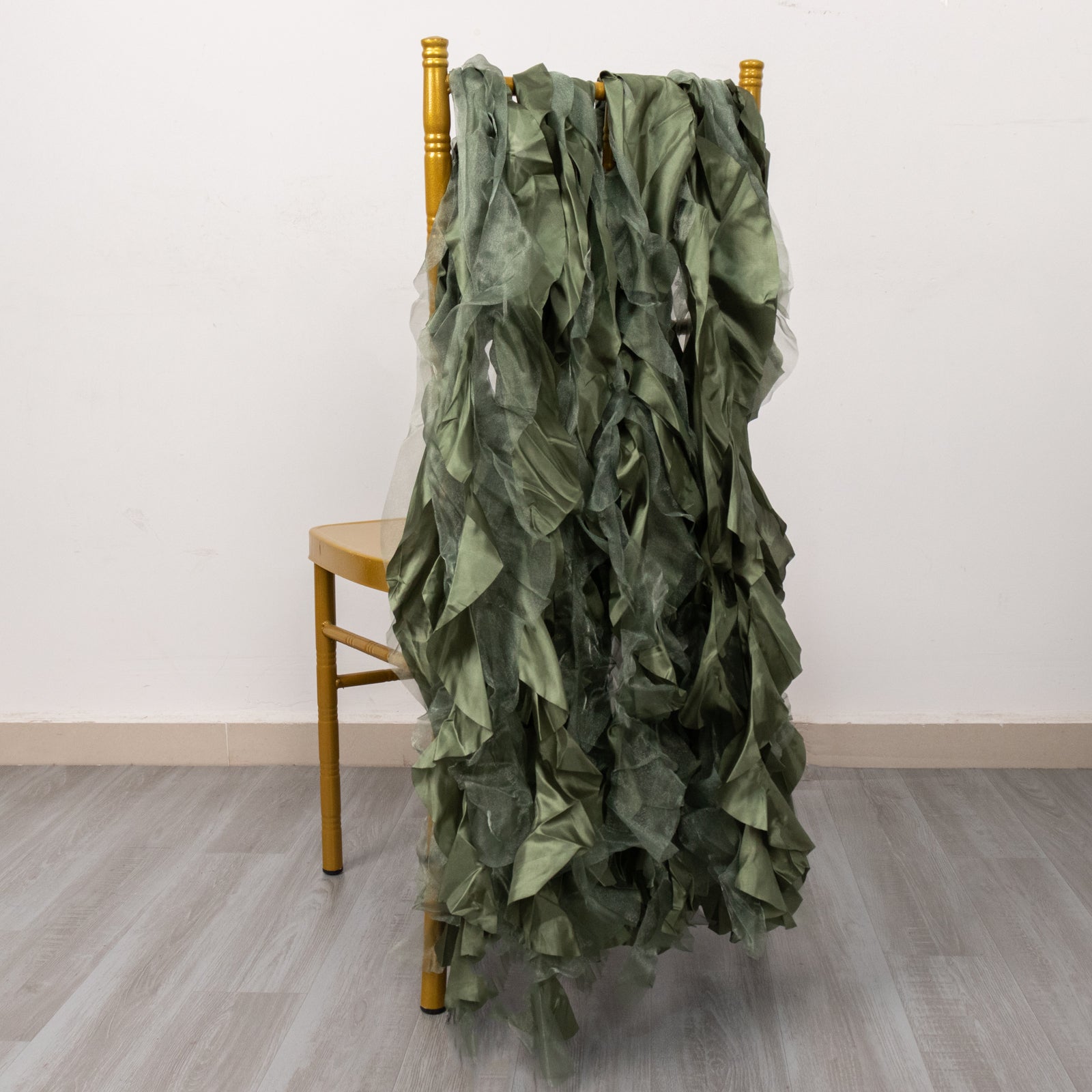 Dusty sage green curly willow chiffon satin chair sashes on a chair.
