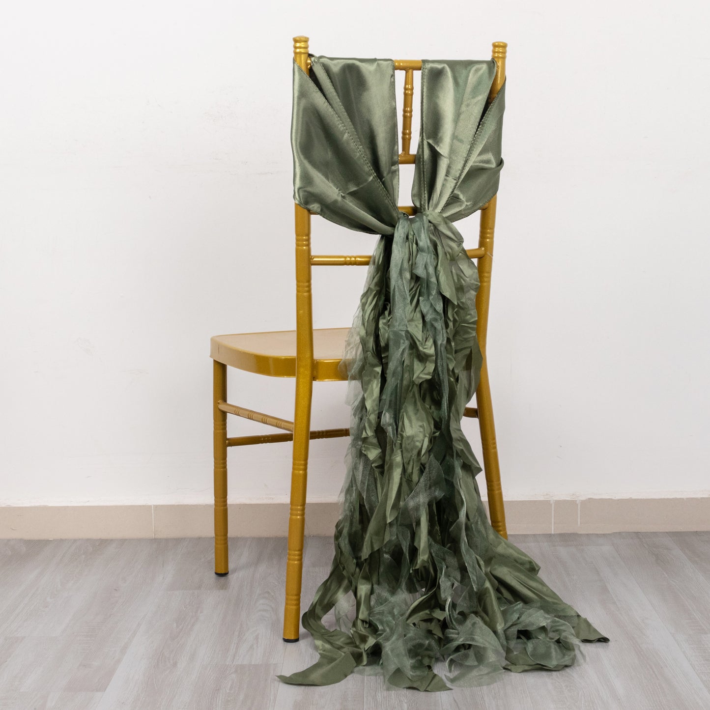 Dusty sage green curly willow chiffon satin chair sash on a gold chair.