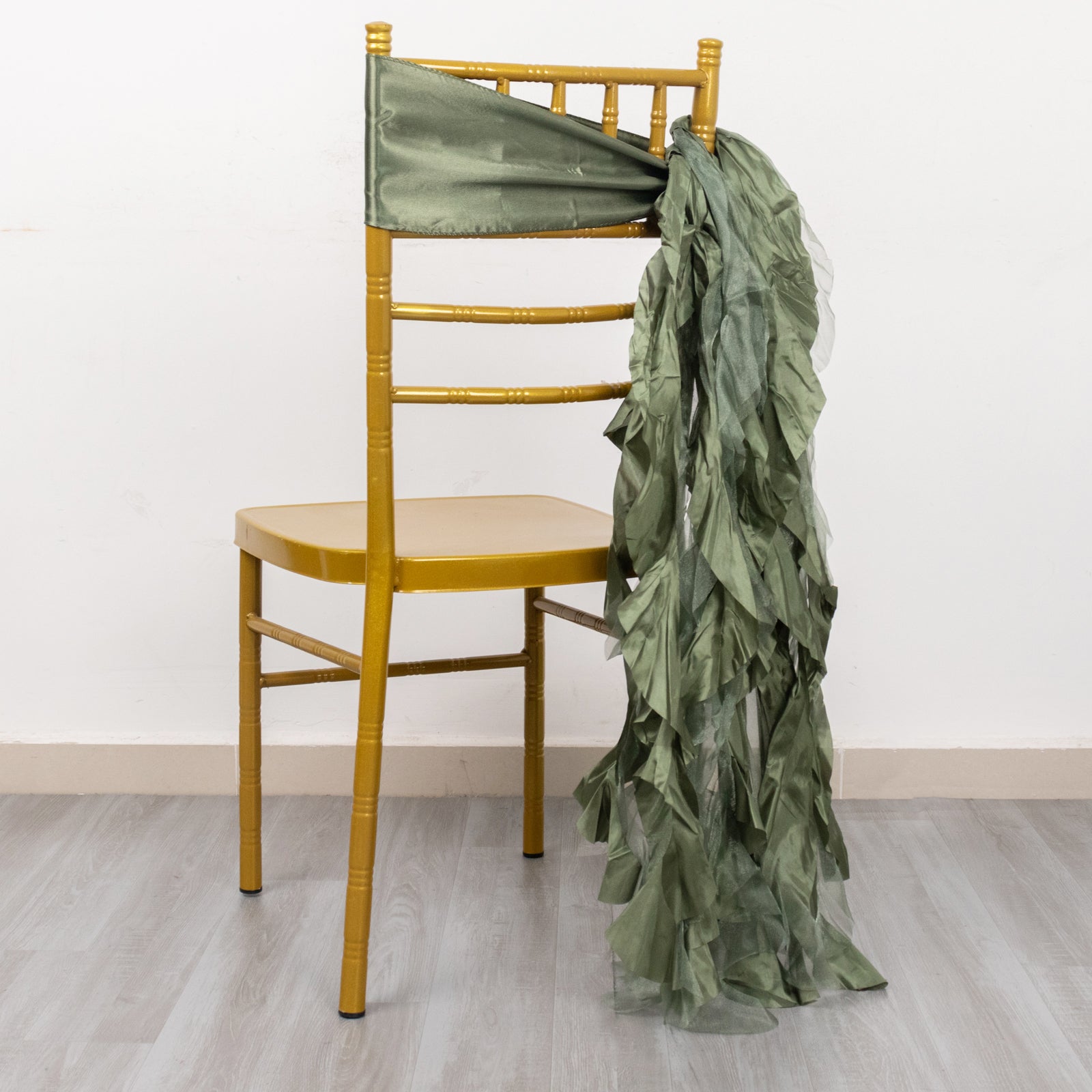 Dusty sage green curly willow chiffon satin chair sash on a gold chair.