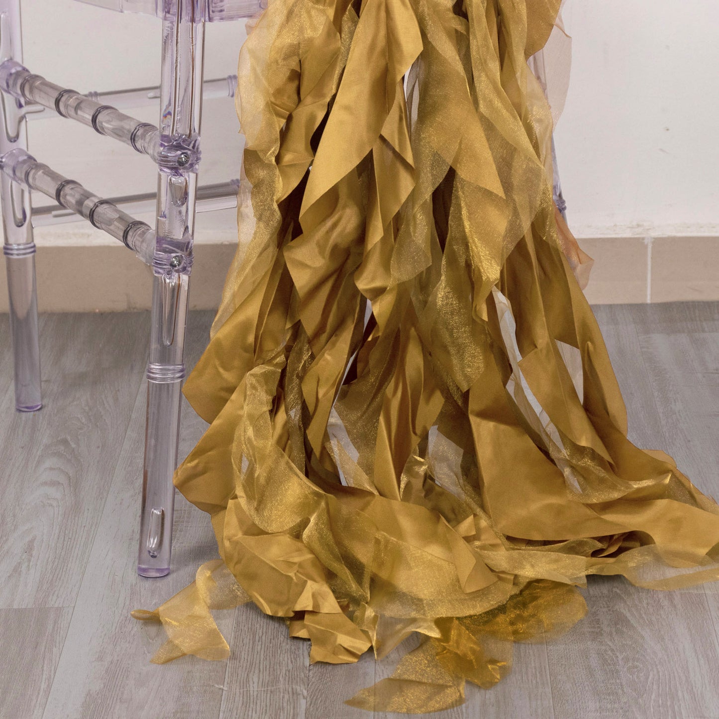 Gold curly chiffon satin chair sashes draped elegantly on a chair.