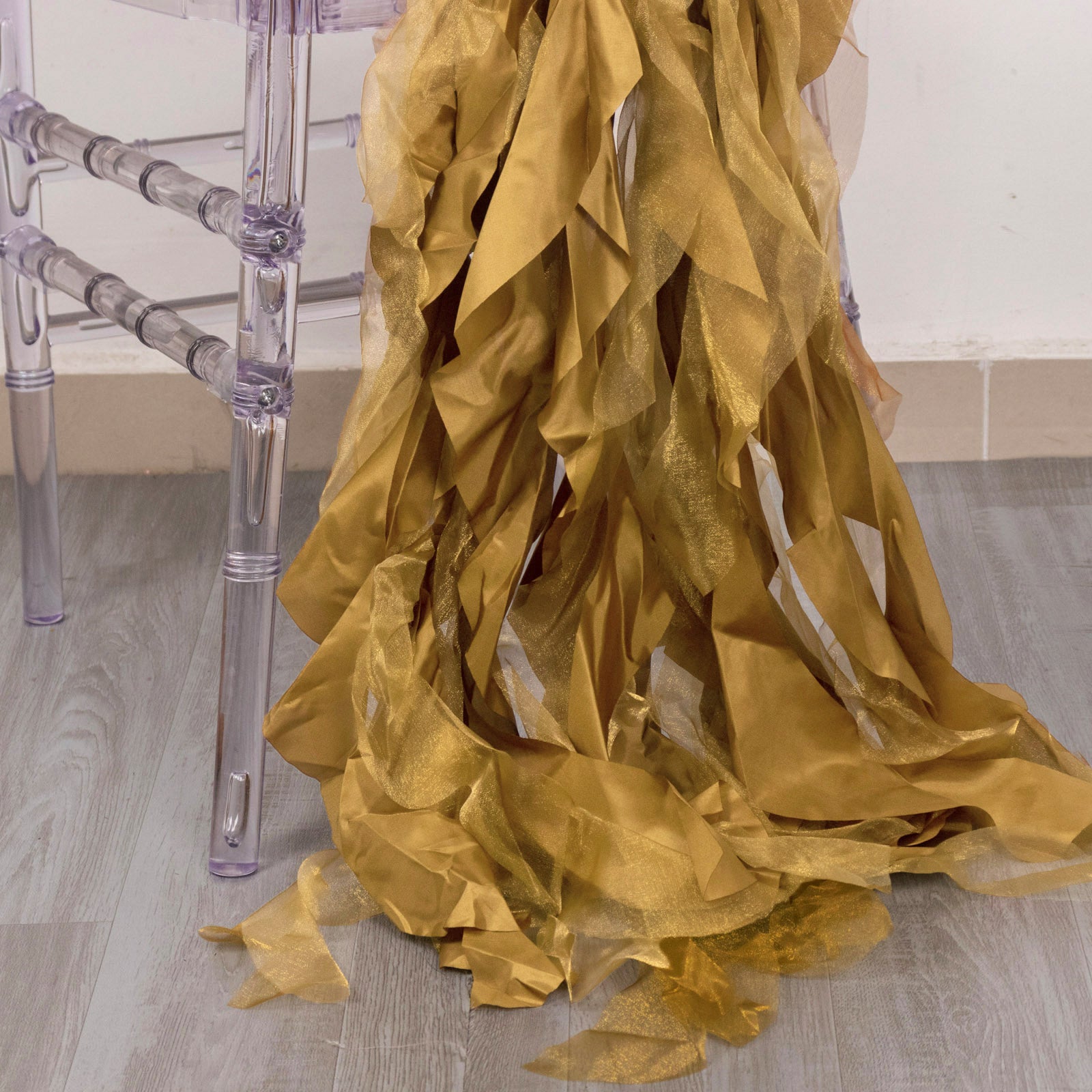 Gold curly chiffon satin chair sashes draped elegantly on a chair.