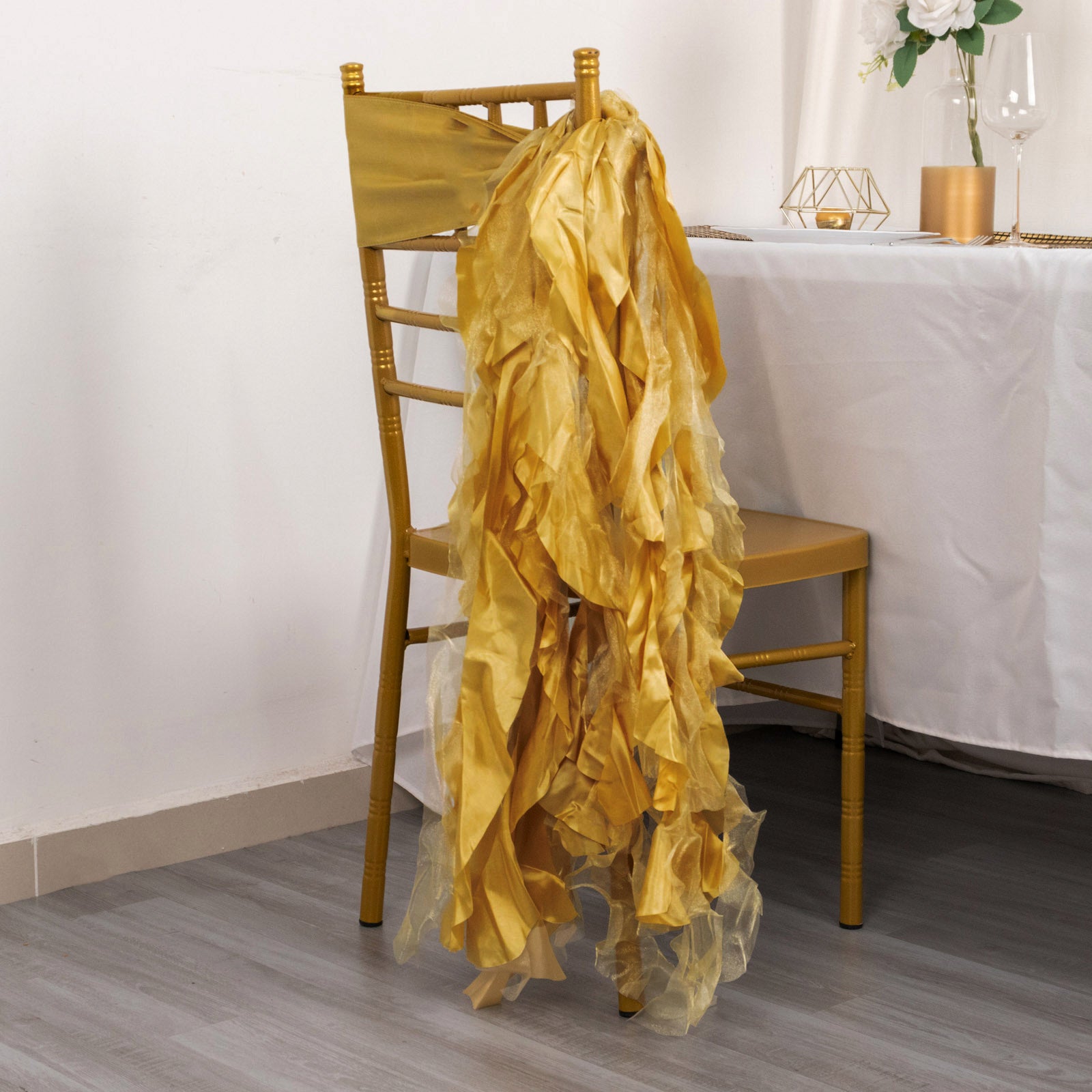Gold curly chiffon satin chair sashes draped over a gold chair.