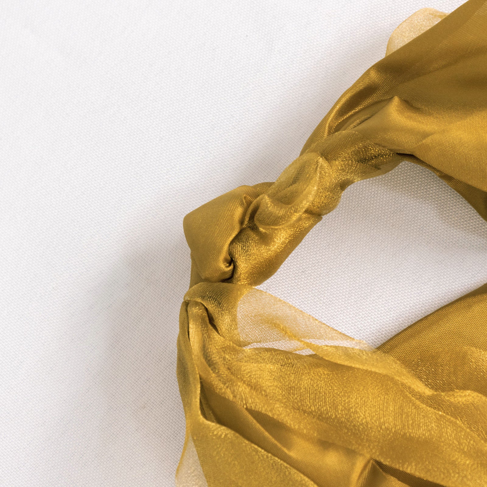 Gold chiffon satin chair sash tied in a knot.