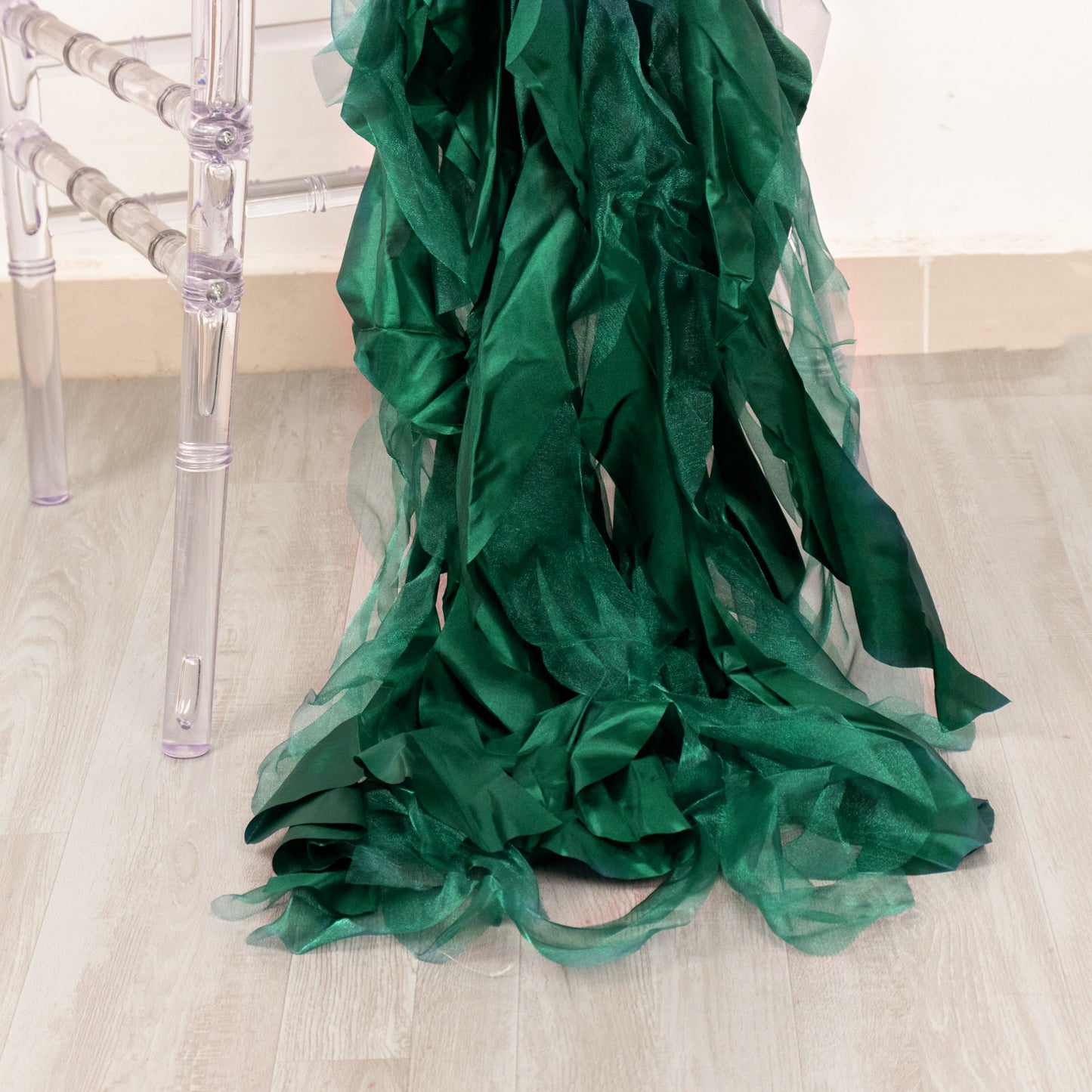 Emerald green chiffon satin chair sashes draped elegantly on a chair.