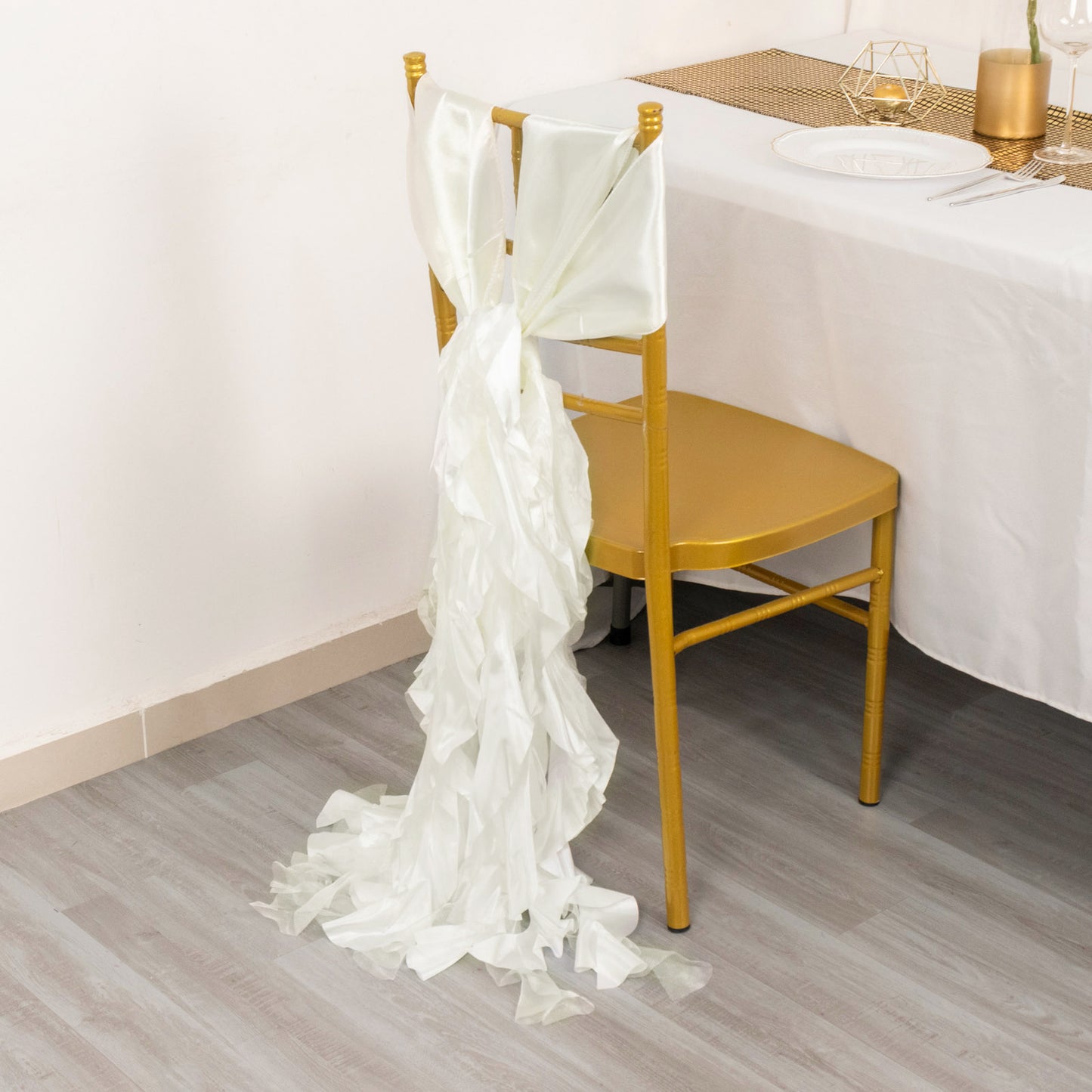 Ivory curly chiffon satin chair sashes on a gold chair.