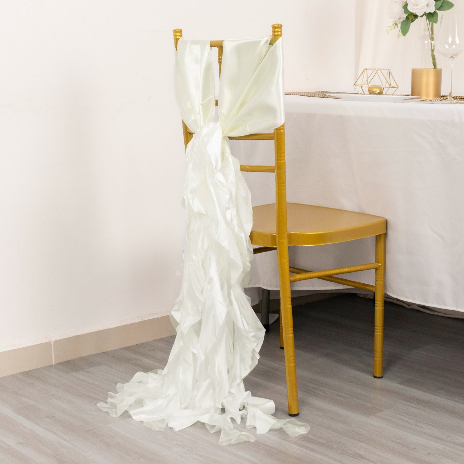 Ivory satin chair sash tied on a golden chair.