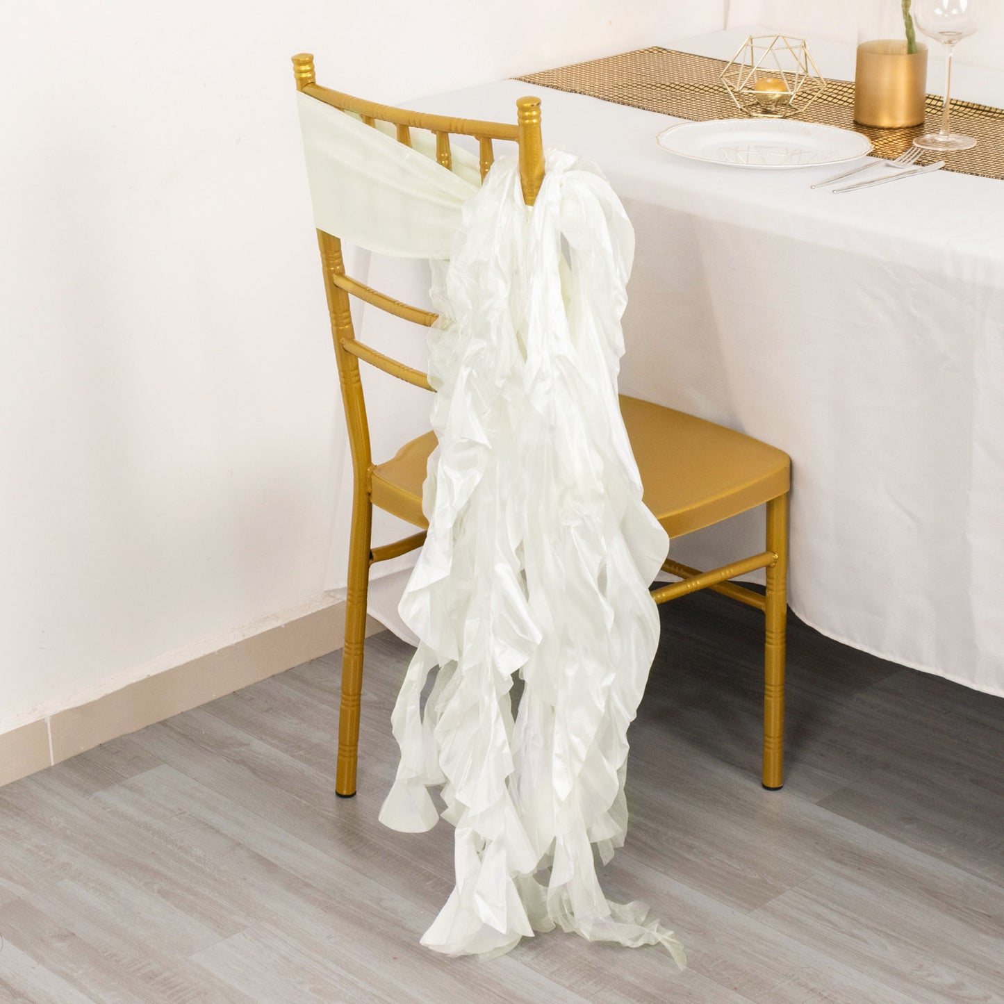 Ivory curly willow chiffon satin chair sash draped on a golden chair.