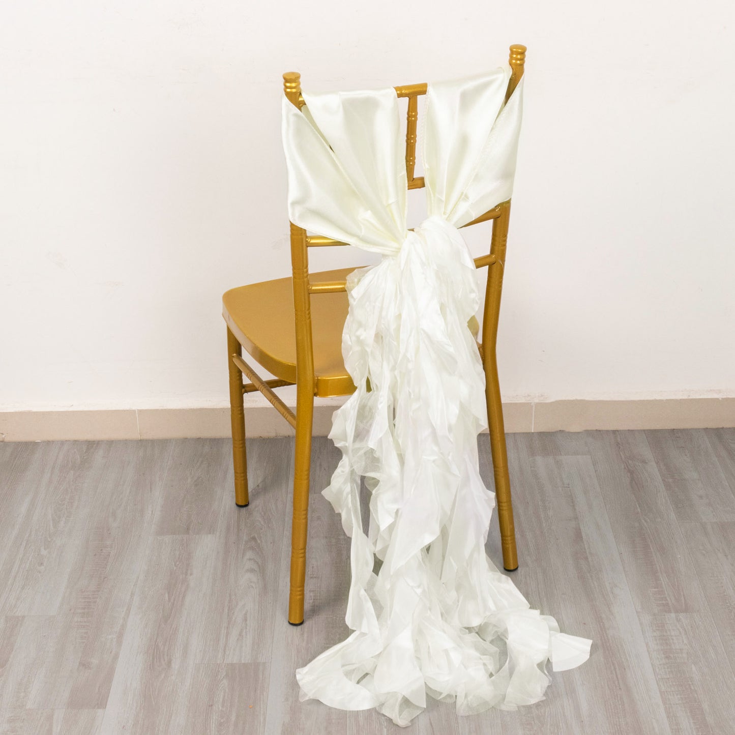 Ivory curly willow chiffon satin chair sash on a gold chair.