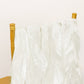 Ivory chiffon satin chair sashes draped over a gold chair.