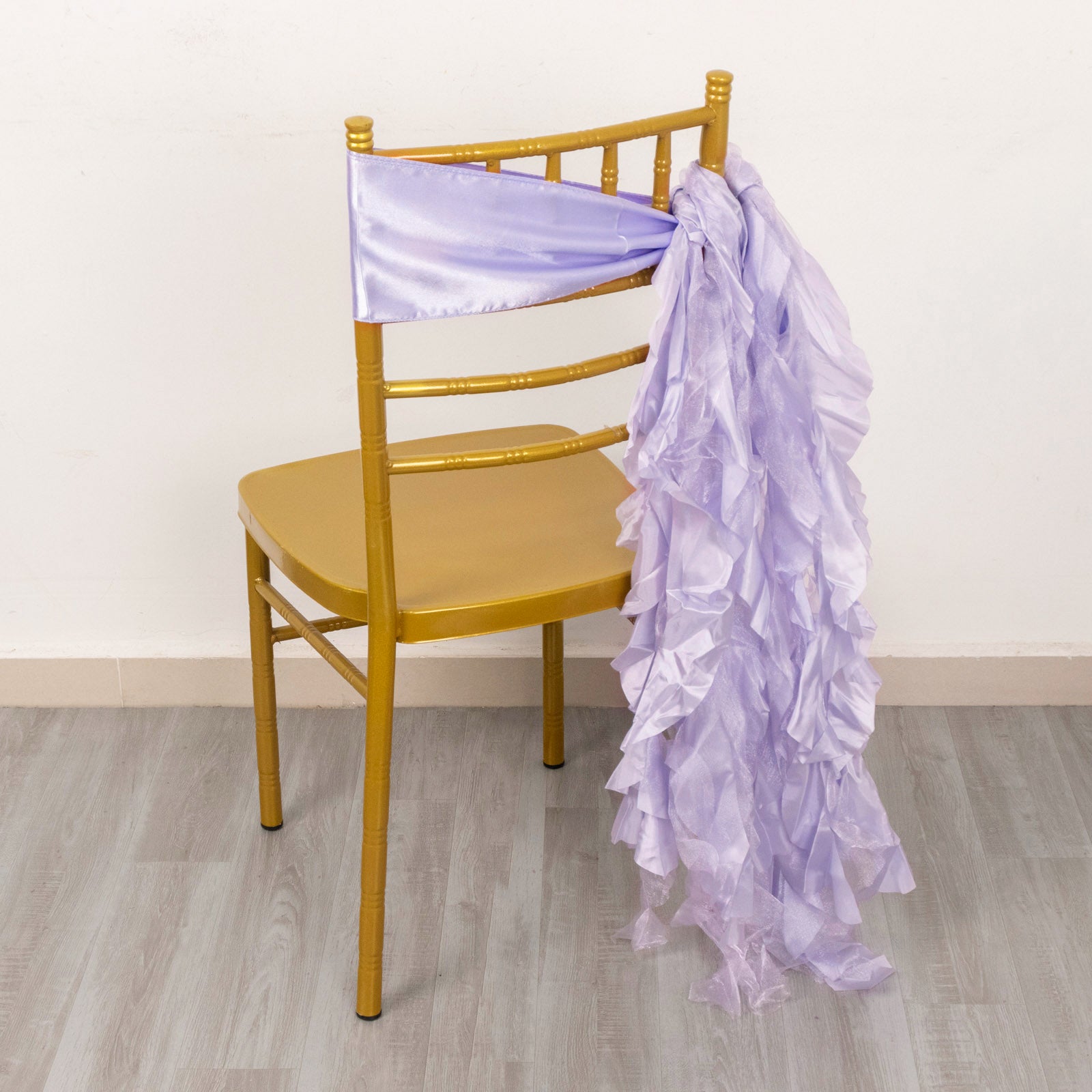 Lavender lilac chiffon satin chair sash draped on a gold chair.