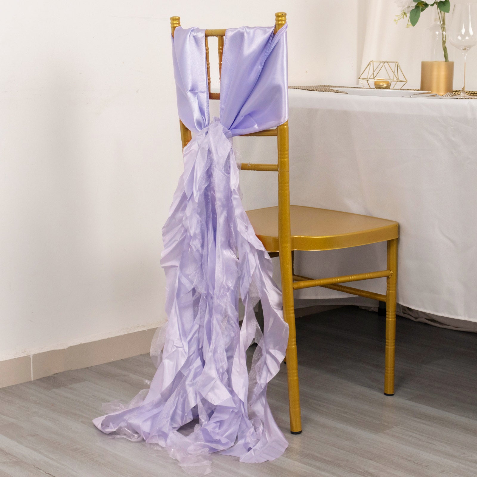 Lavender chiffon satin chair sash draping elegantly over a gold chair.