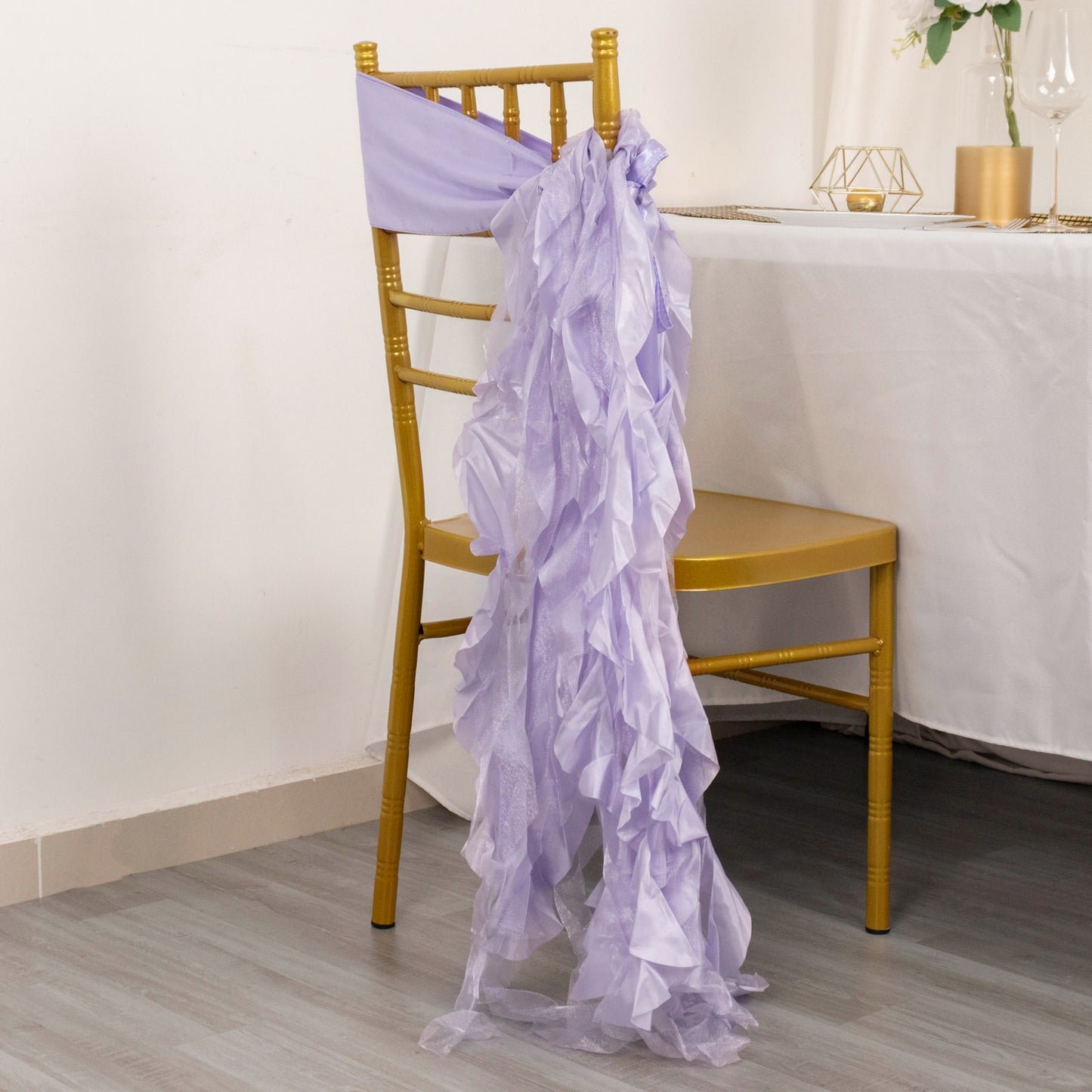 Lavender lilac chiffon satin chair sashes draped elegantly on a gold chair.